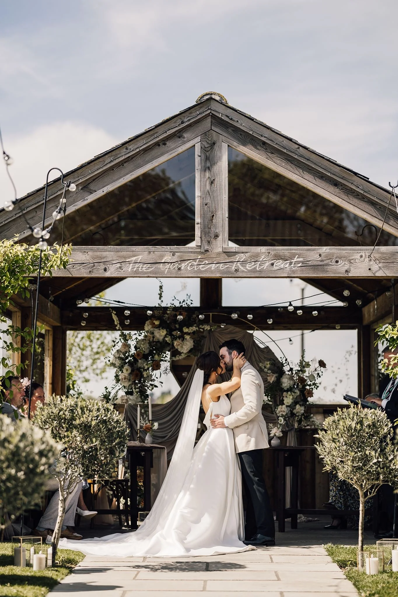 Rachel and Harry sharing their first kiss beneath the ceremony shelter