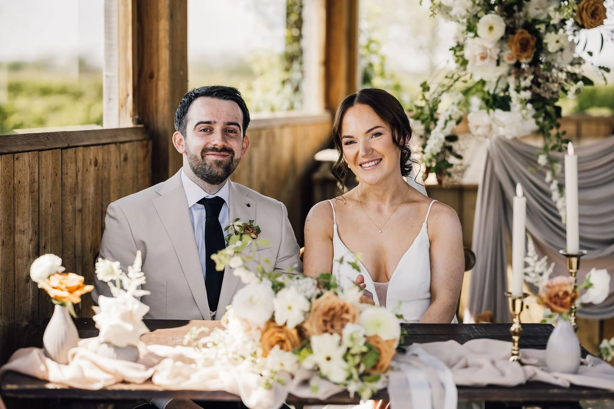Rachel and Harry smiling at the signing table after their ceremony