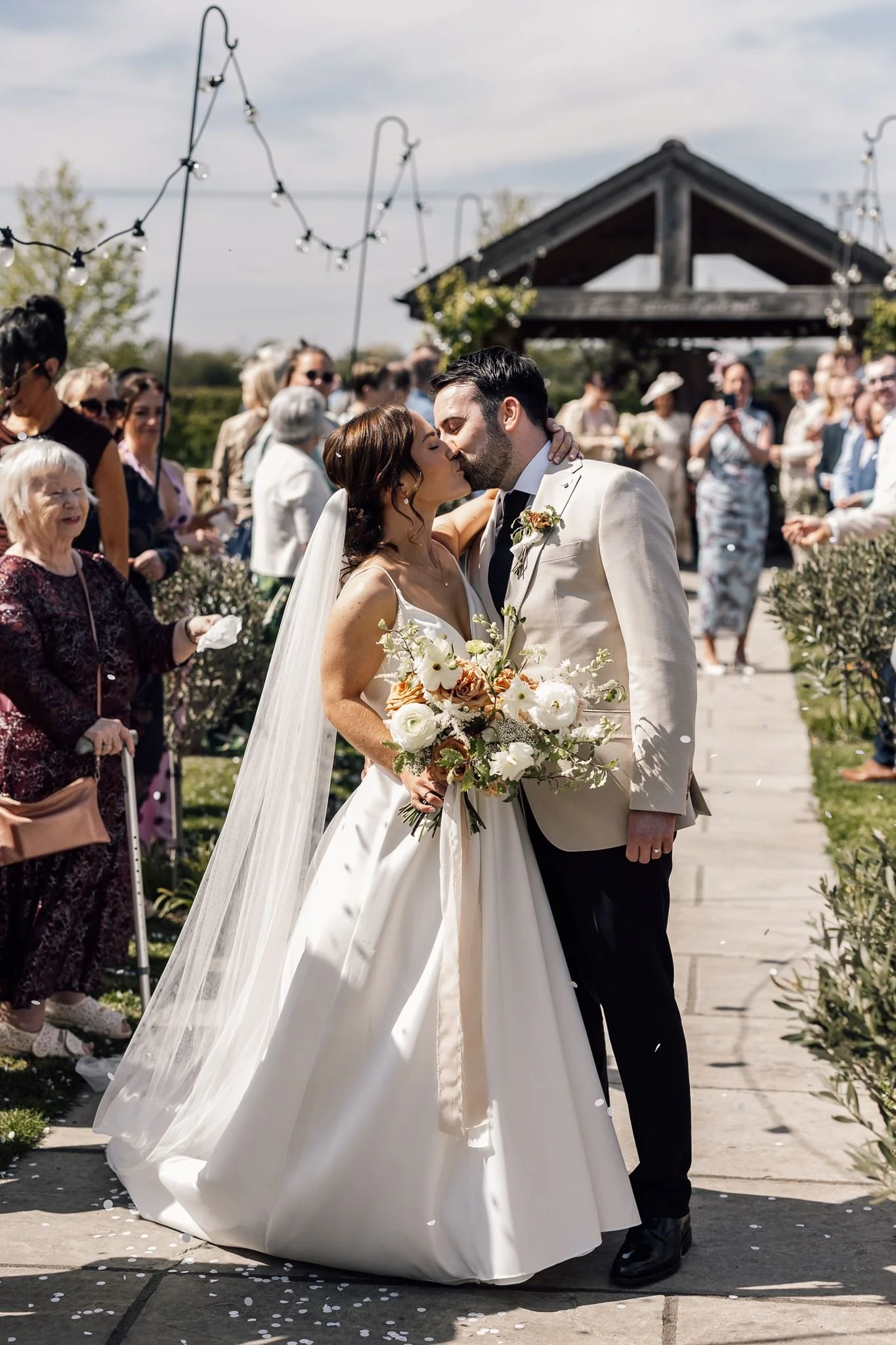 Rachel laughing beside Harry in a shower of wedding confetti