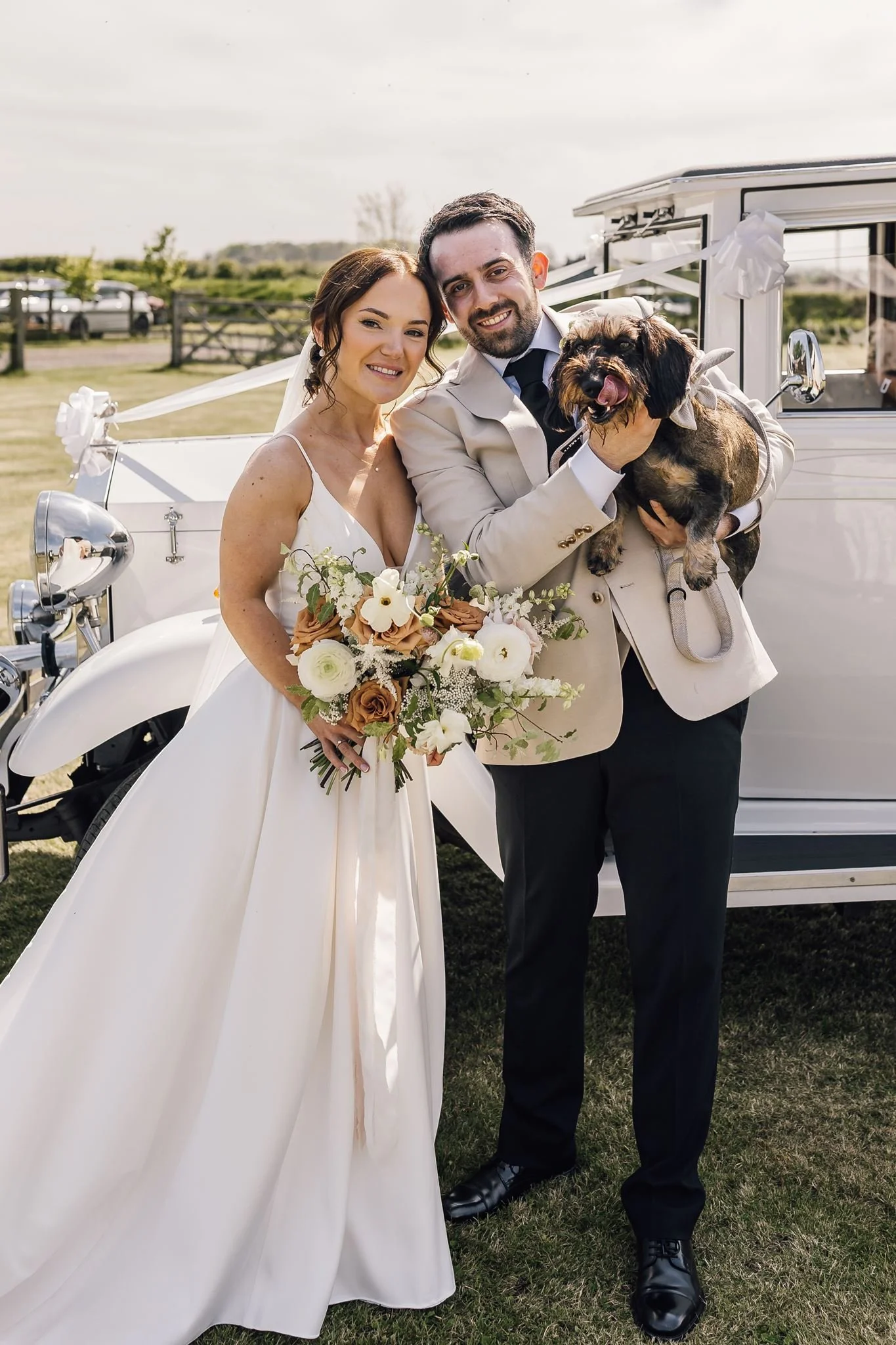 Rachel and Harry holding Dottie for a wedding photograph