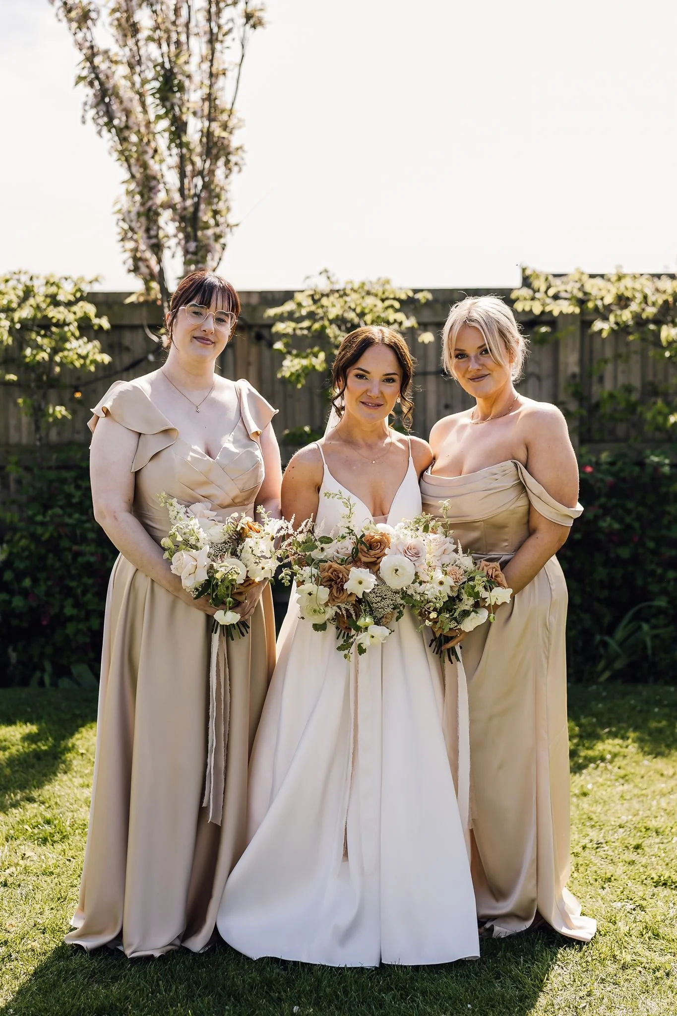 Rachel and her bridesmaids holding their bouquets in the garden