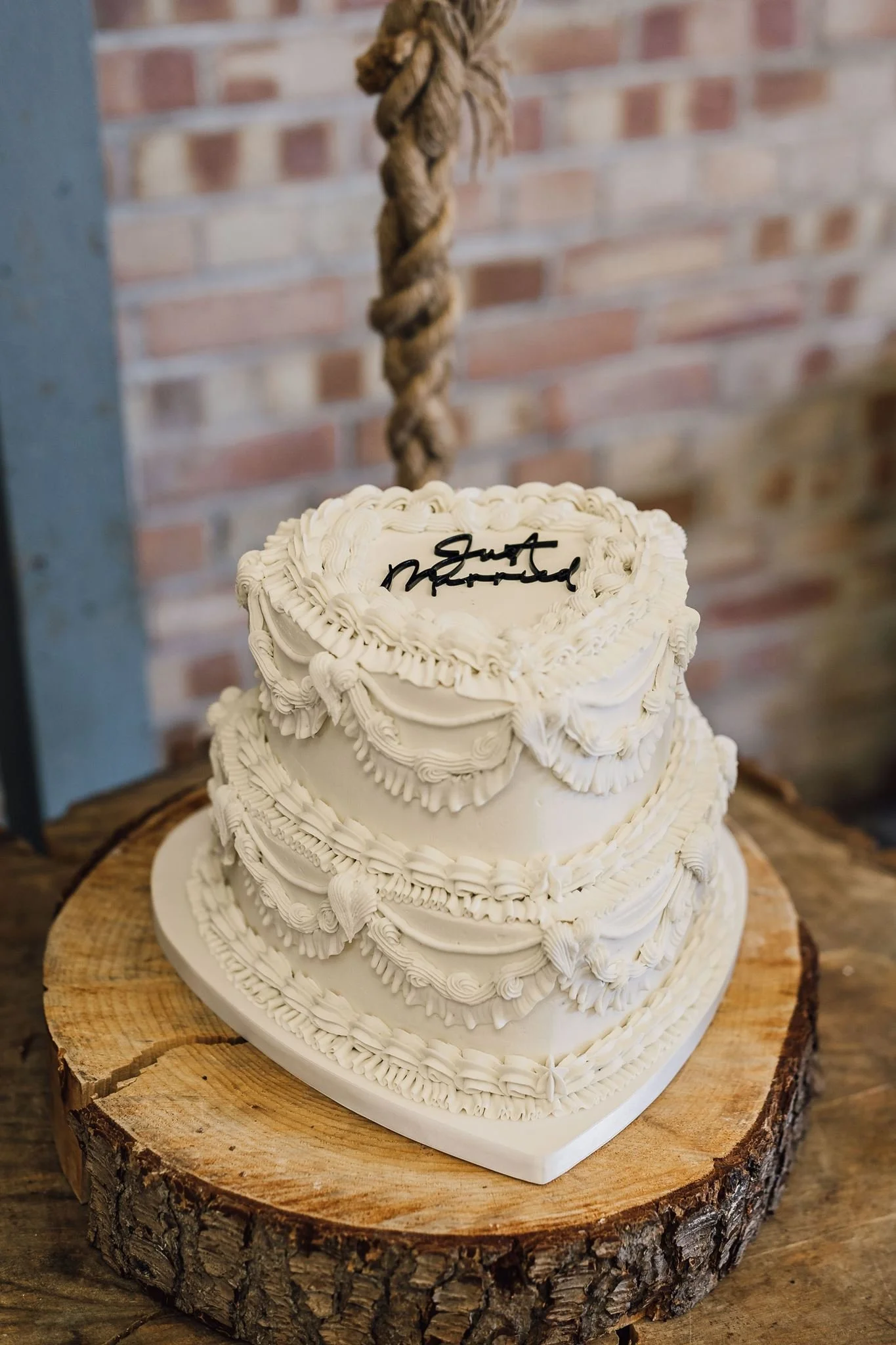 A white wedding cake decorated with piped icing and flowers