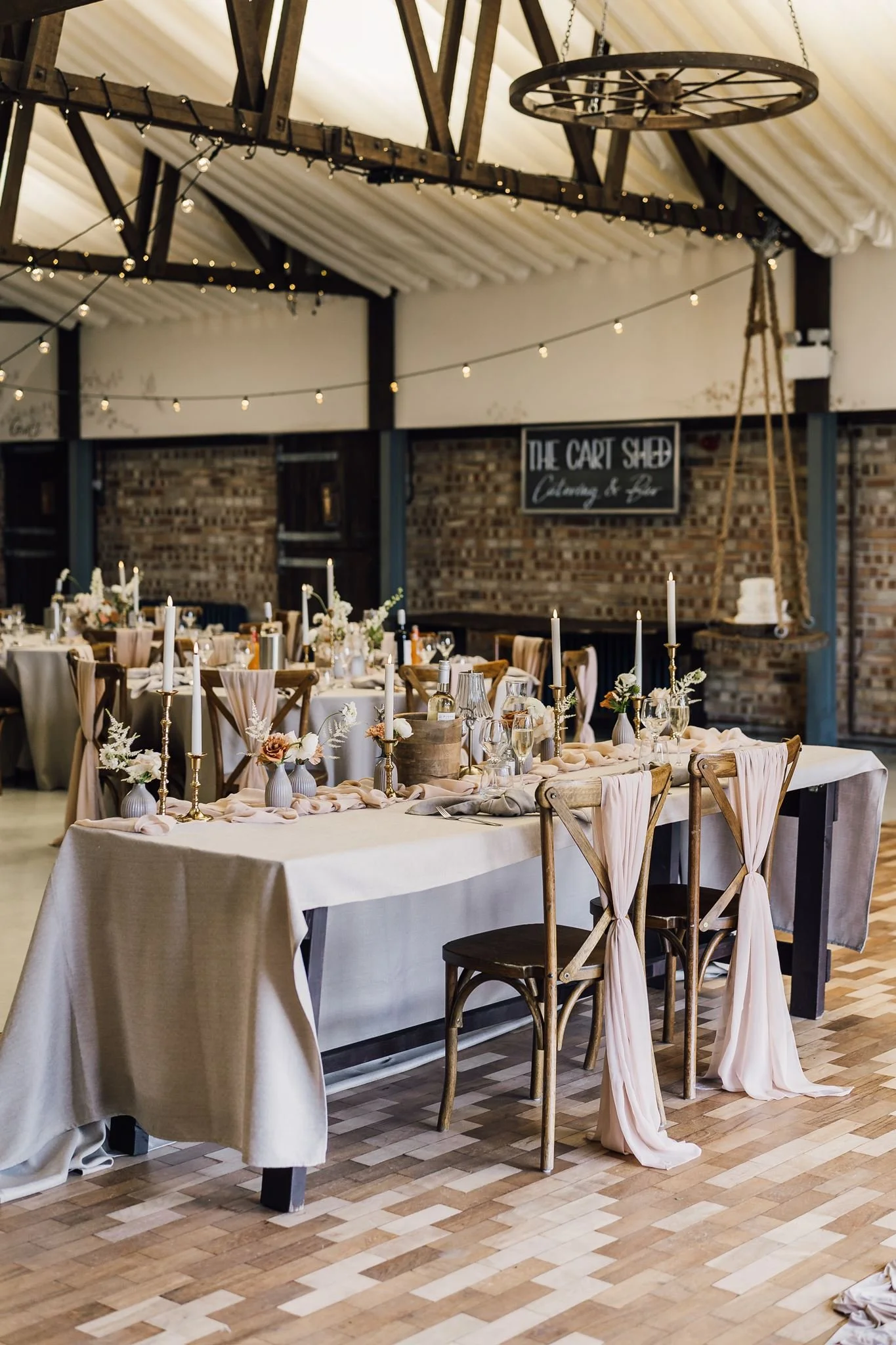 Pale floral table decorations inside the barn reception room