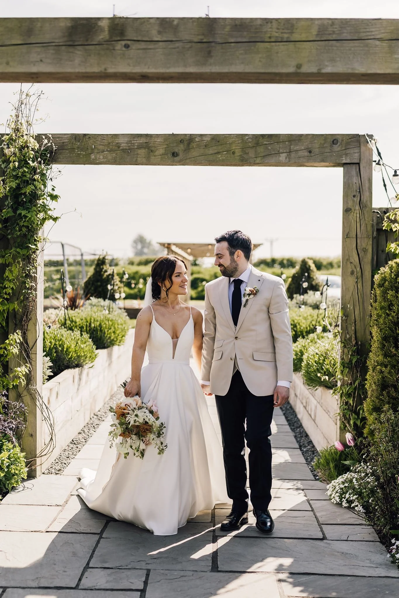 Rachel and Harry walking hand in hand along the garden path