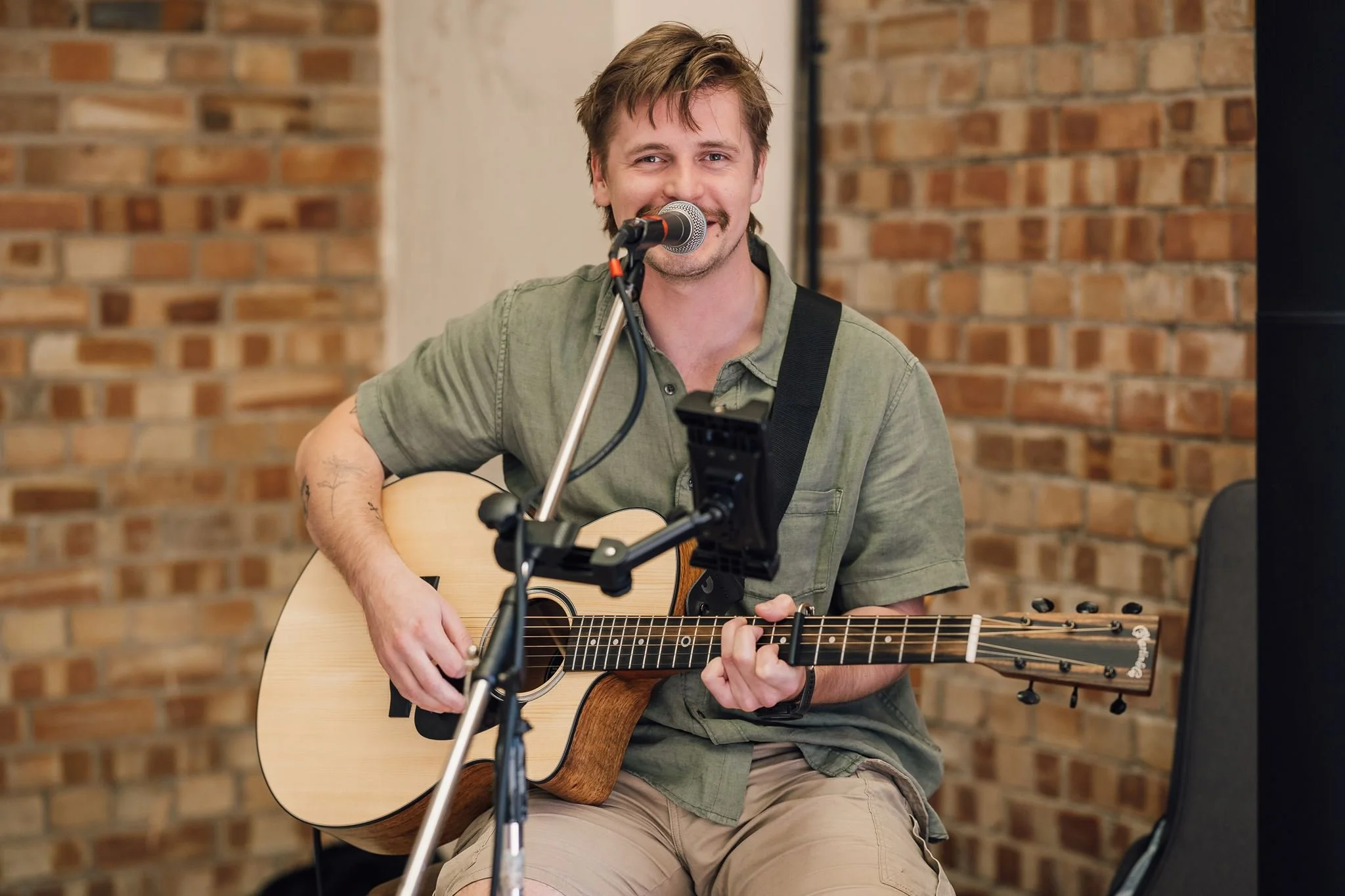 An acoustic guitarist singing inside The Beverley Barn
