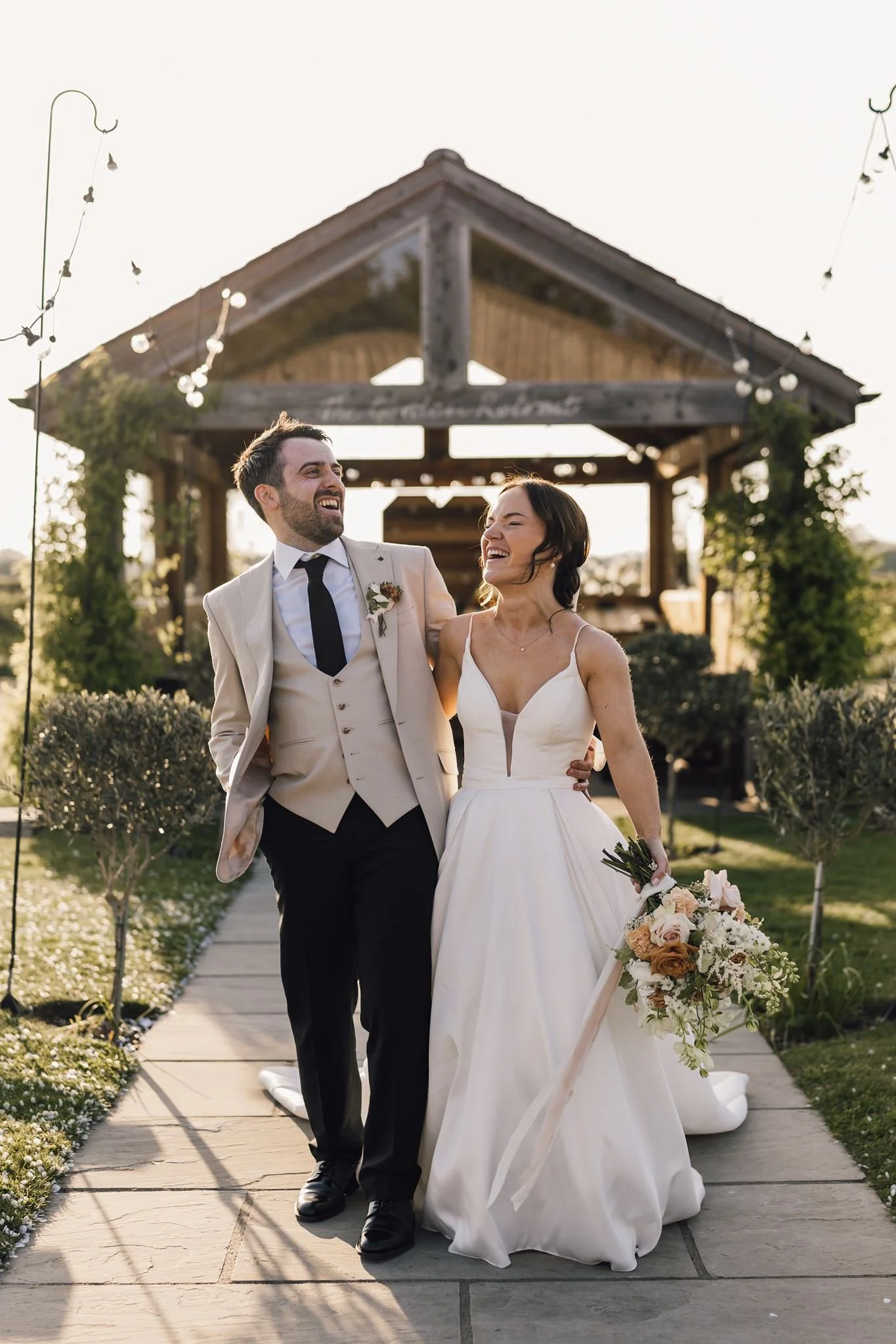 Rachel and Harry walking away from the outdoor ceremony shelter