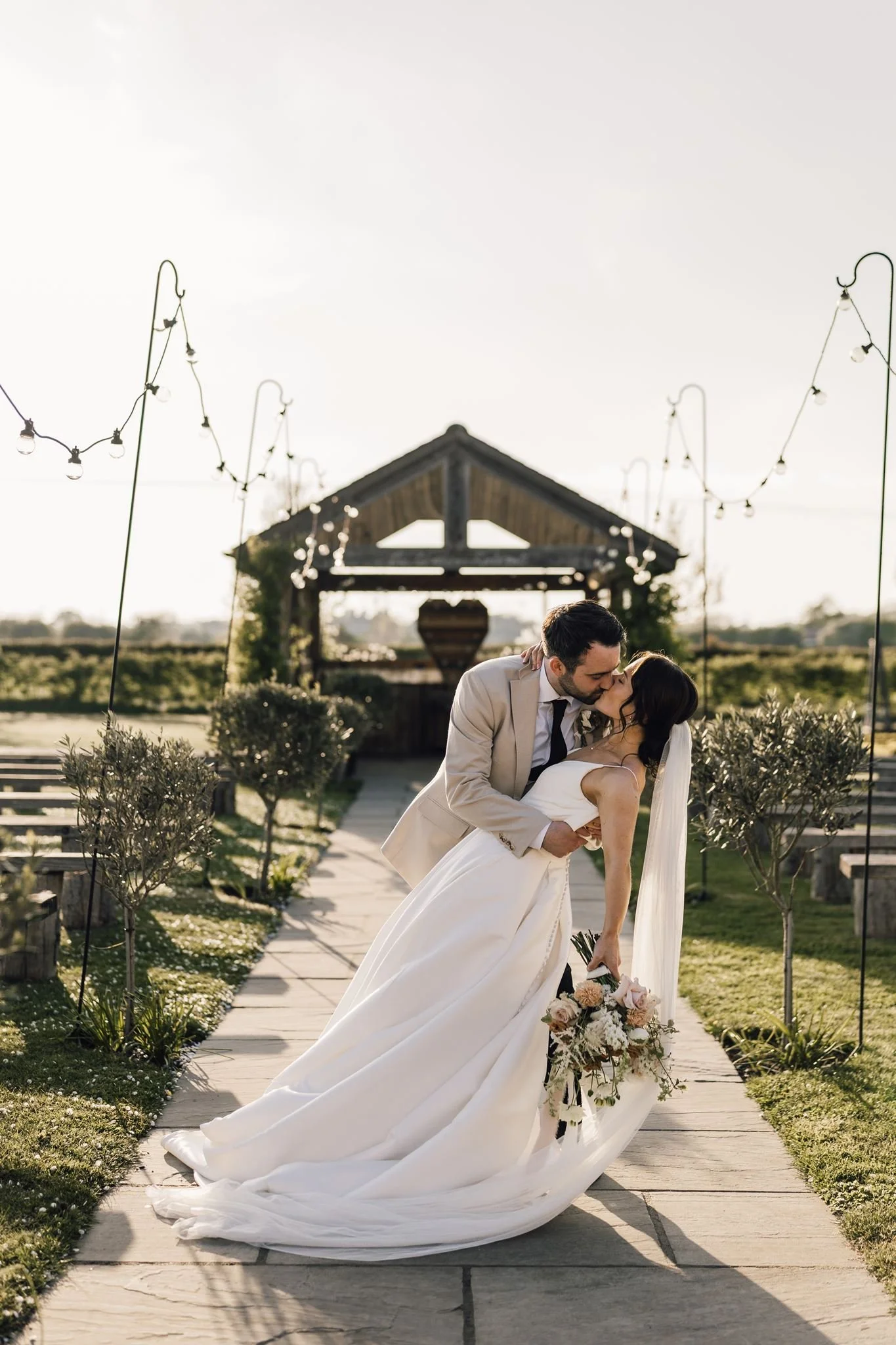 Rachel smiling with Harry beside the outdoor wedding aisle