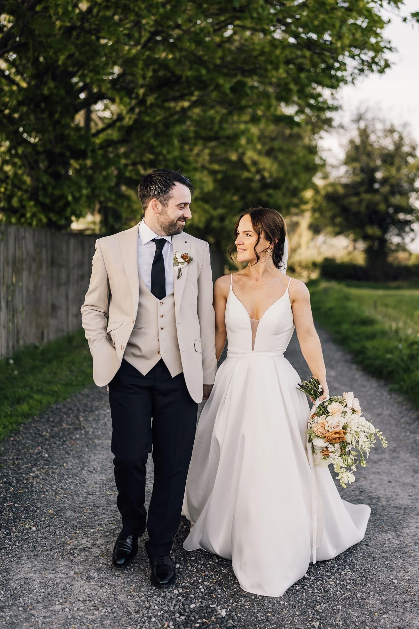 Rachel and Harry walking together beneath the trees