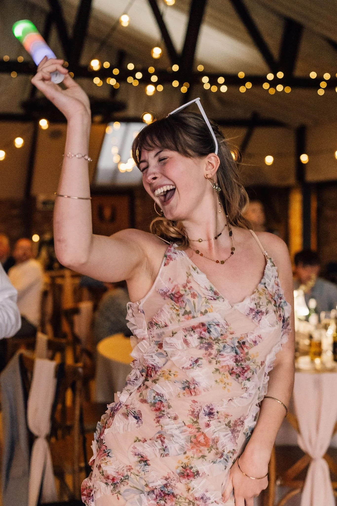 A wedding guest dancing with a light-up foam stick