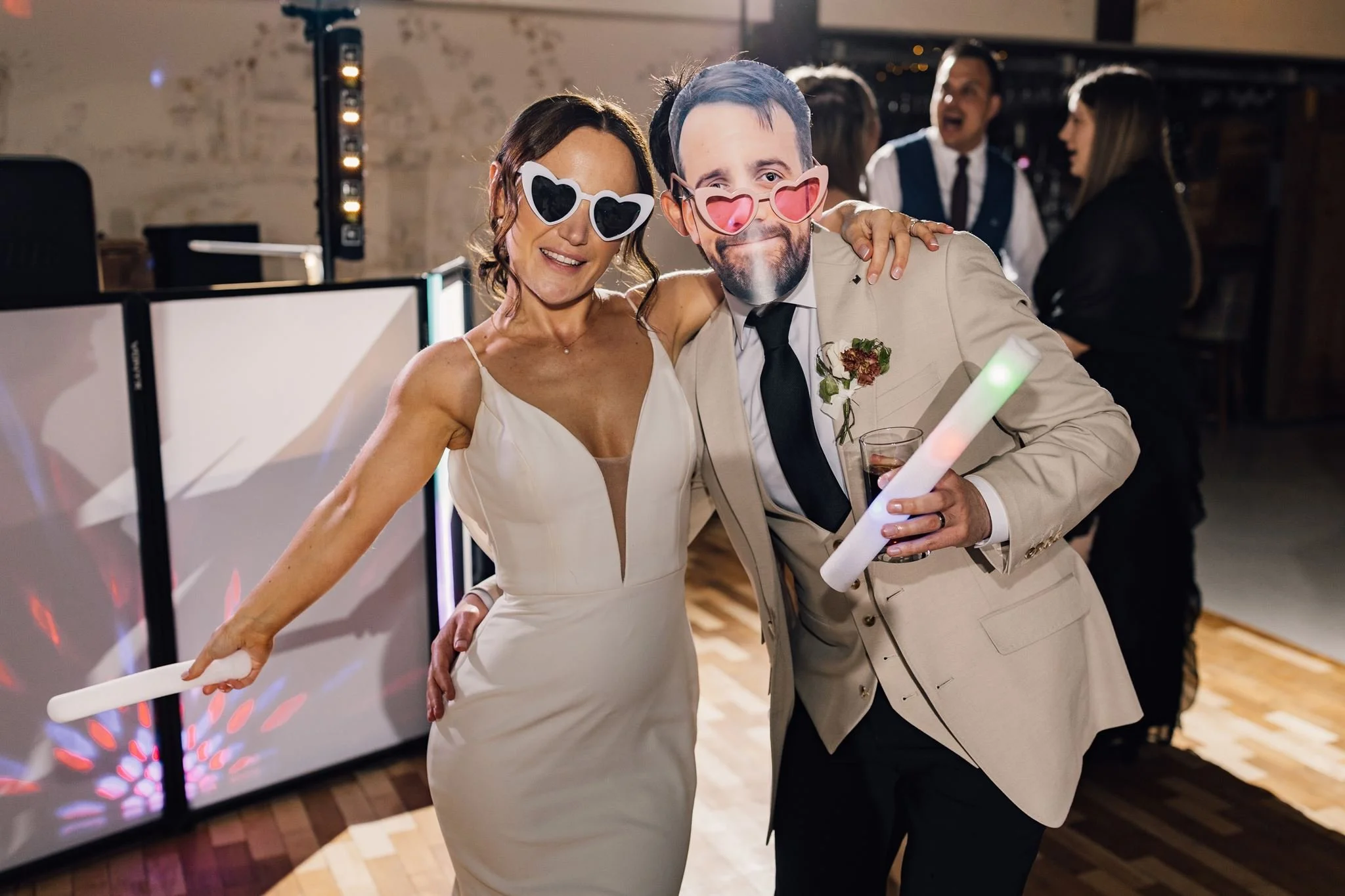 Guests dancing with novelty sunglasses and light-up foam sticks