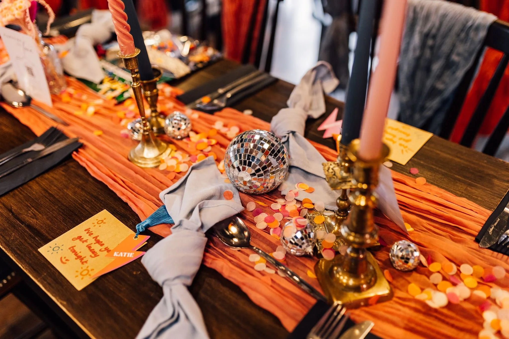 Colourful place setting and floral details on a wedding reception table
