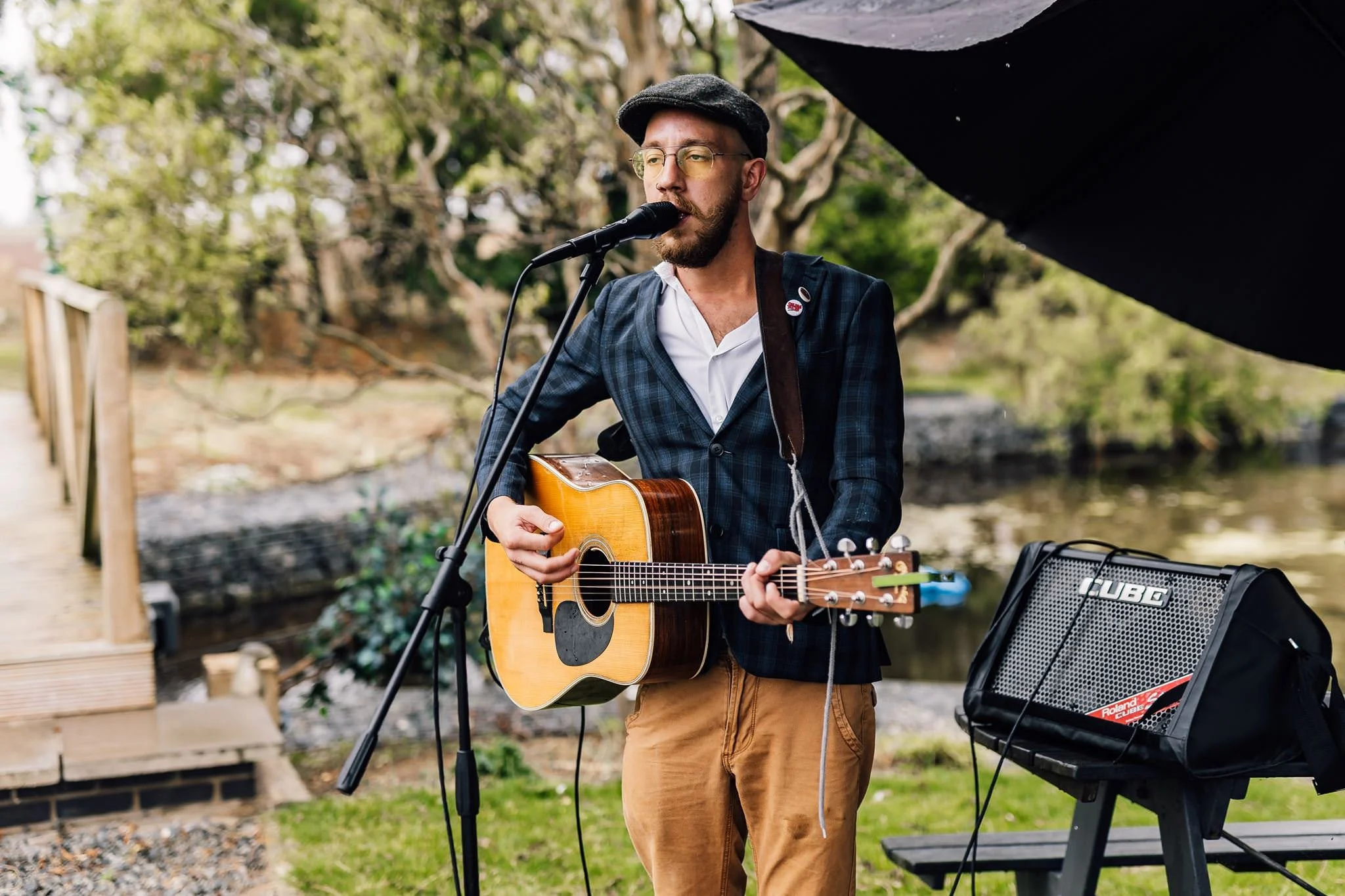 An acoustic guitarist performing outdoors at the wedding