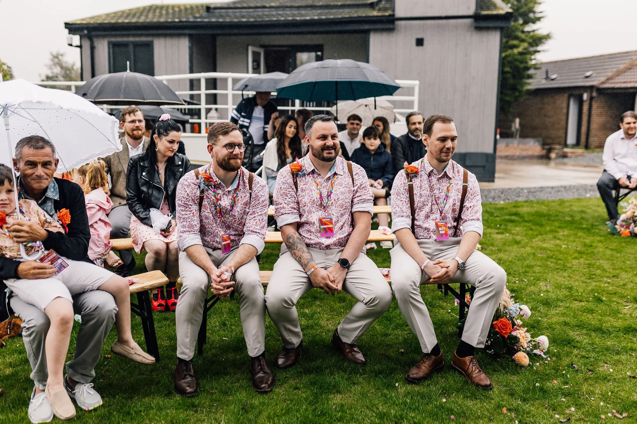 Wedding guests smiling from a bench during the ceremony