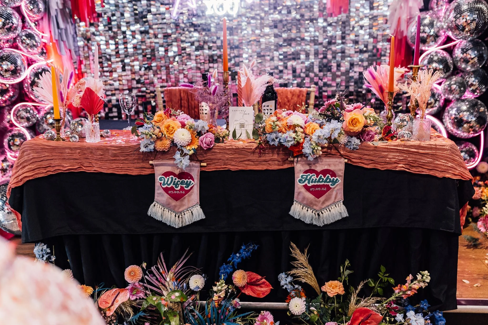 Colourful flowers and disco balls on Chloe and Aaron’s wedding reception table