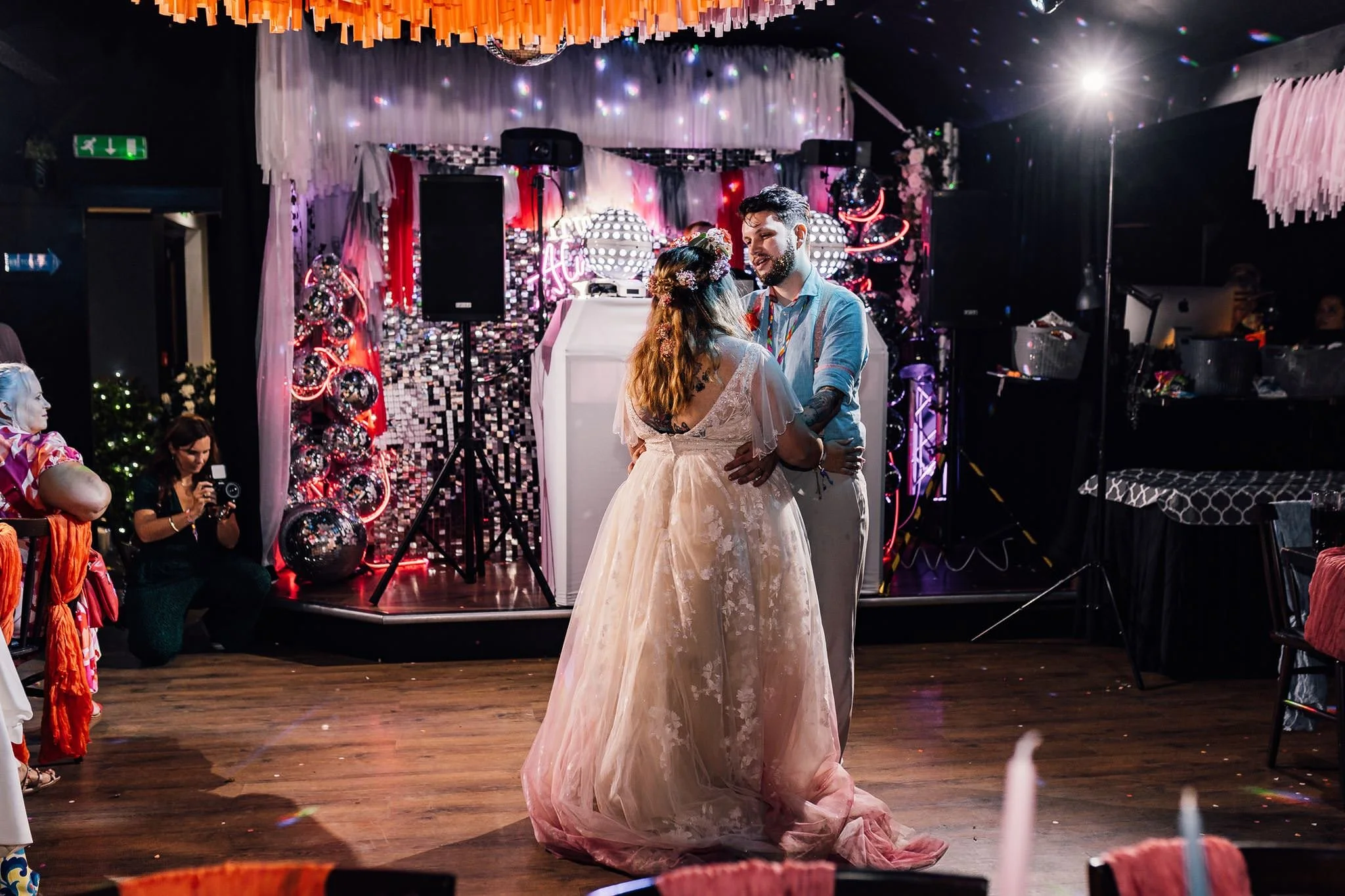 Chloe and Aaron sharing their first dance beneath wedding streamers