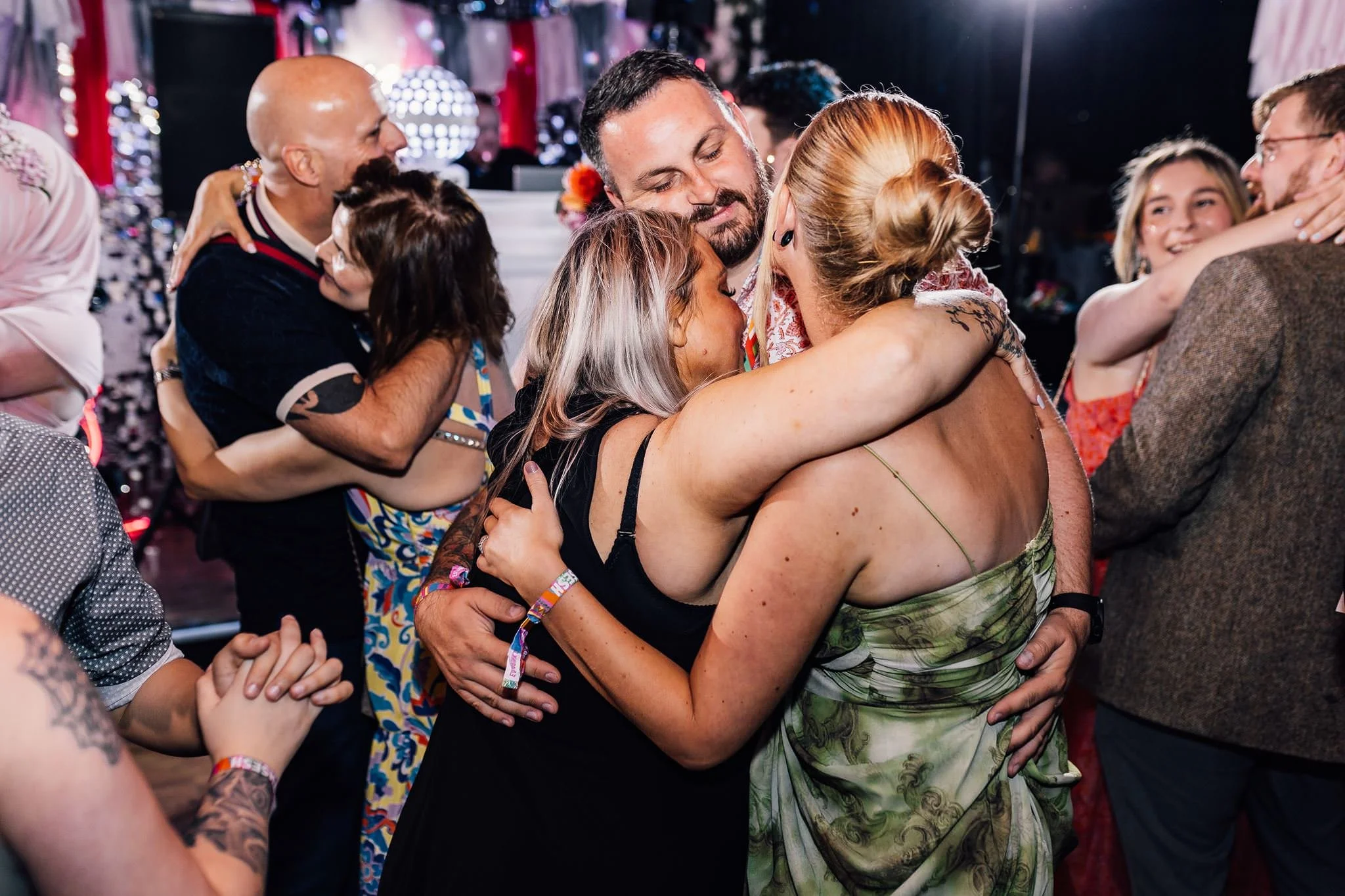 Wedding guests embracing and laughing on the dance floor