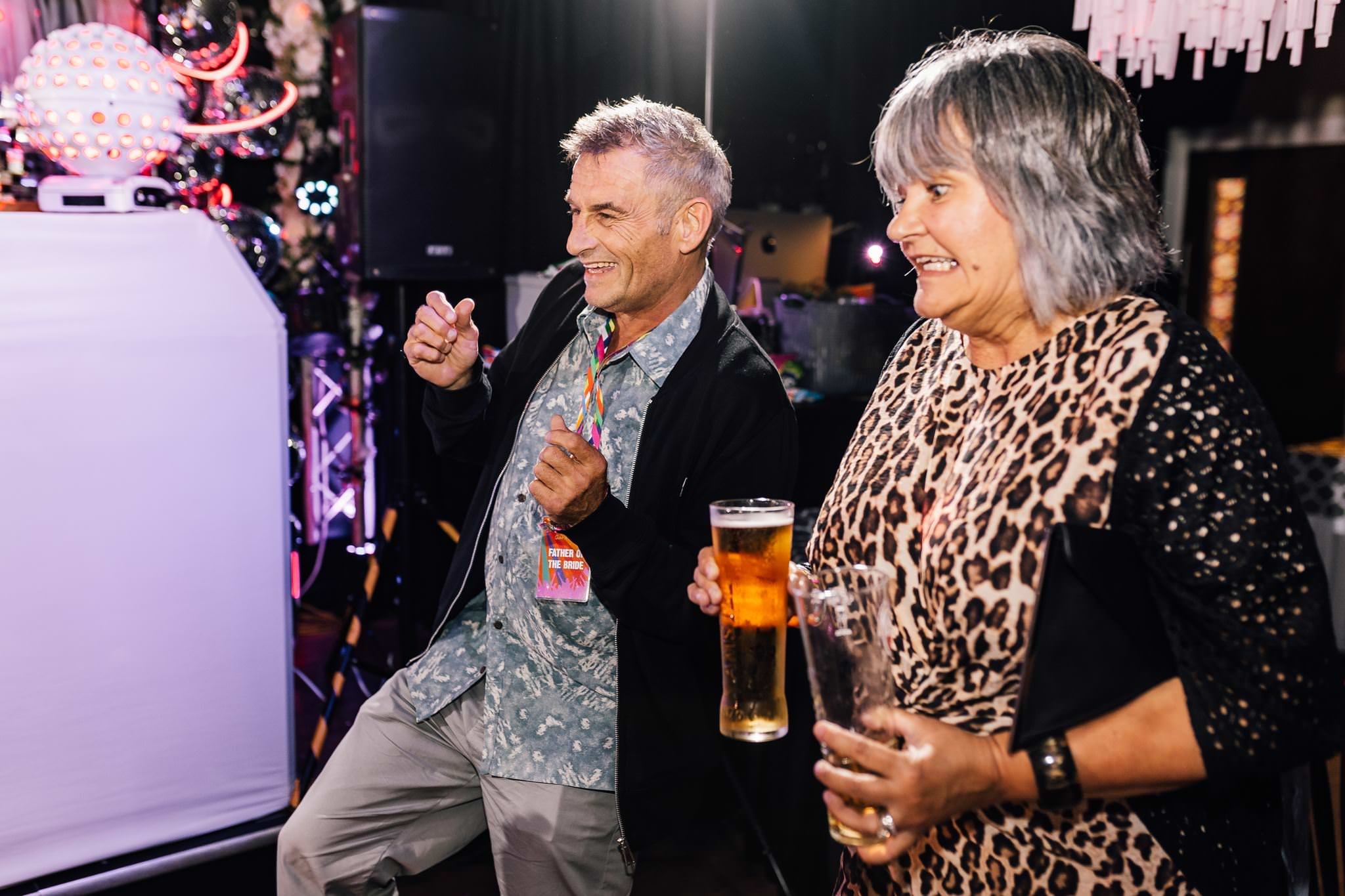 Two guests smiling and holding drinks during the evening reception