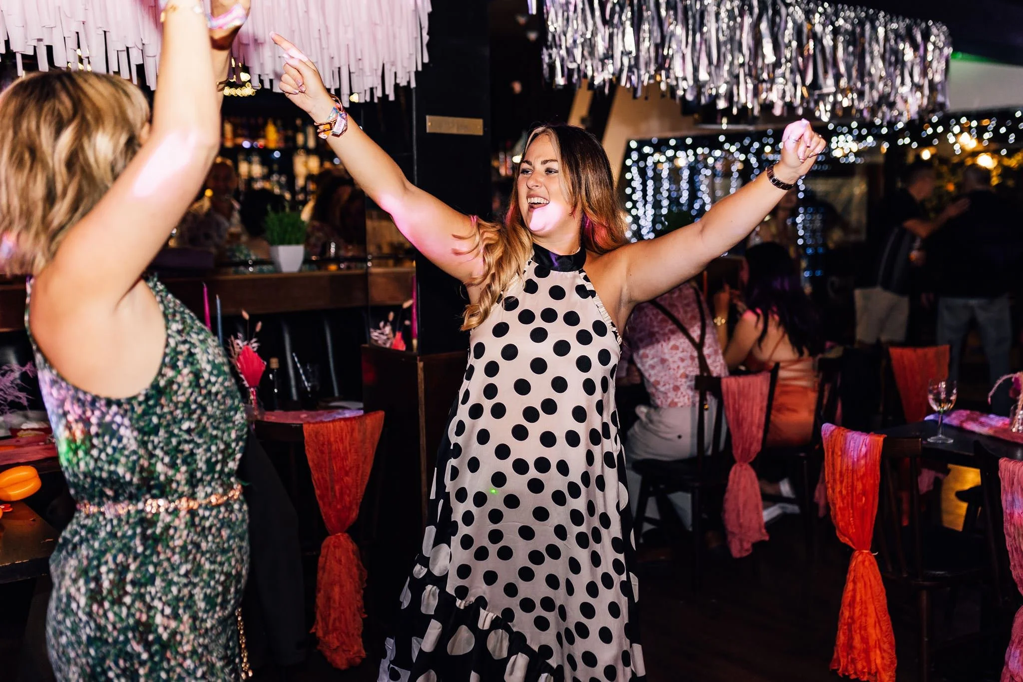 A guest raising her arms on the wedding dance floor