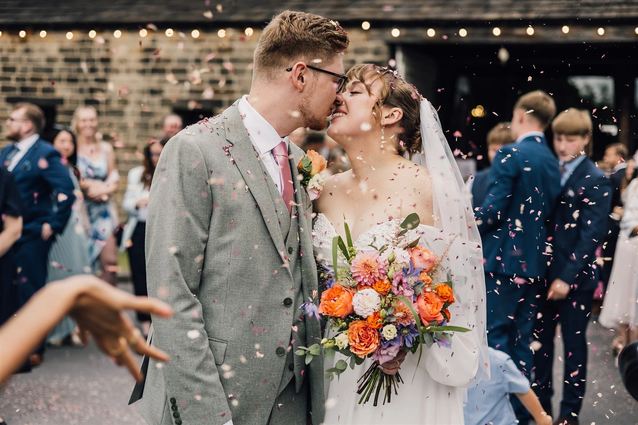Bride and groom kissing during confetti moment at East Riddlesden Hall wedding