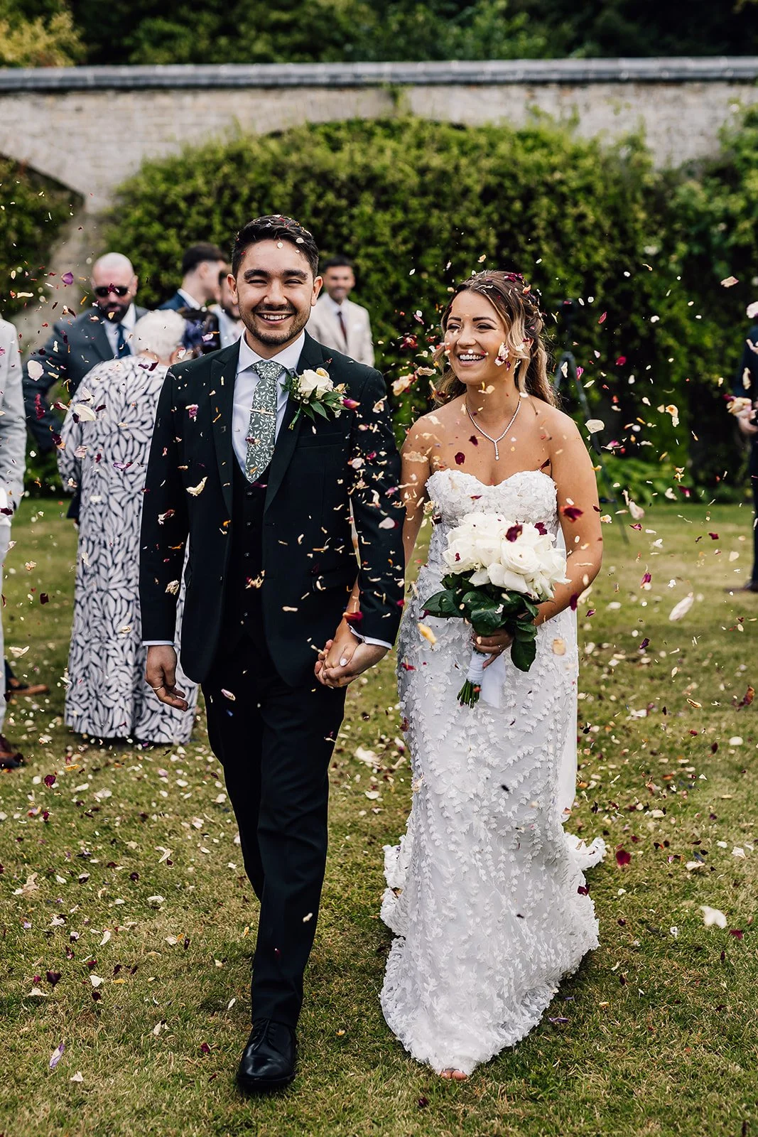 Charlotte and Rory walking through confetti after their wedding ceremony