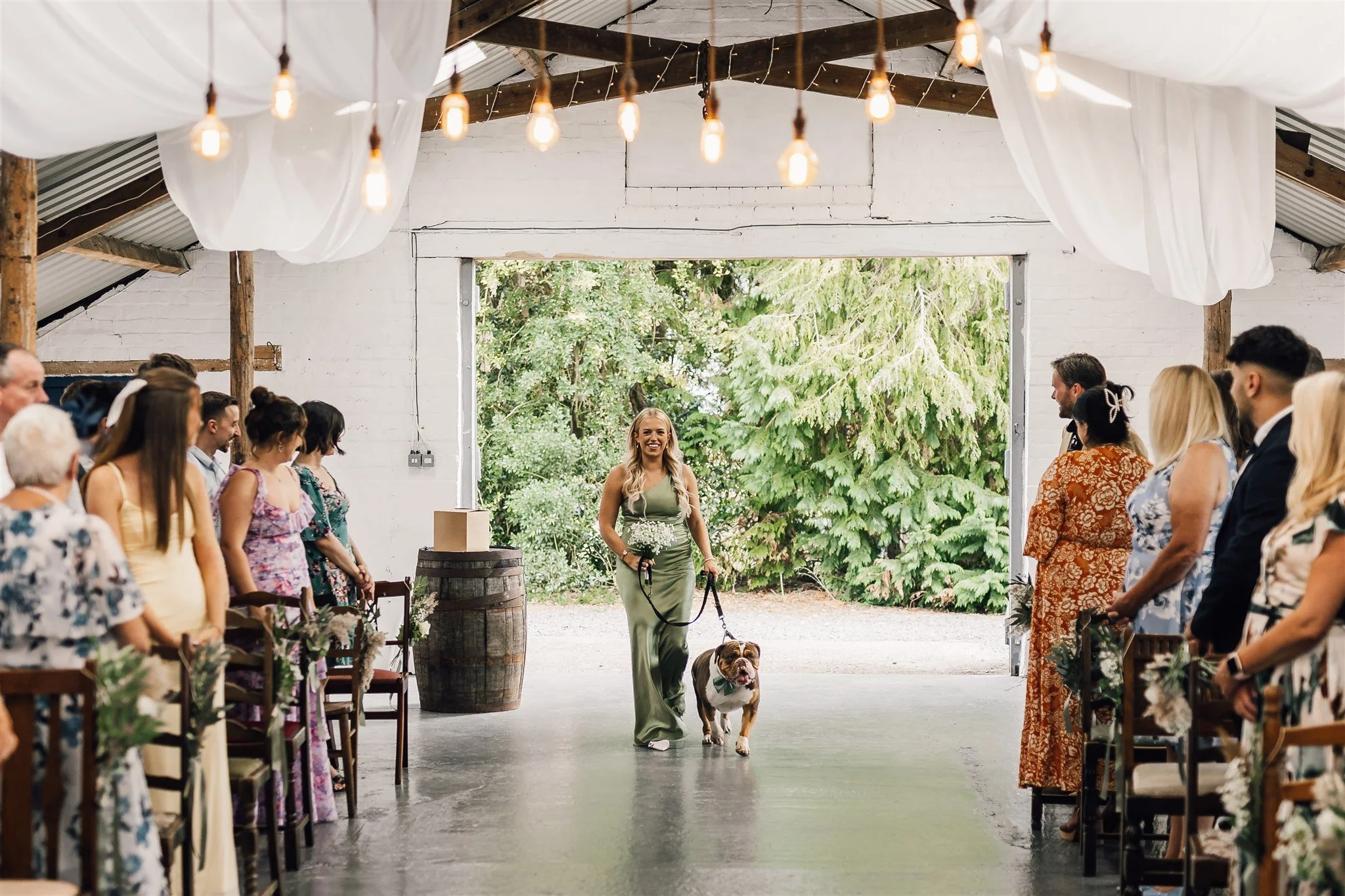 Bridesmaid walking dog down the wedding isle
