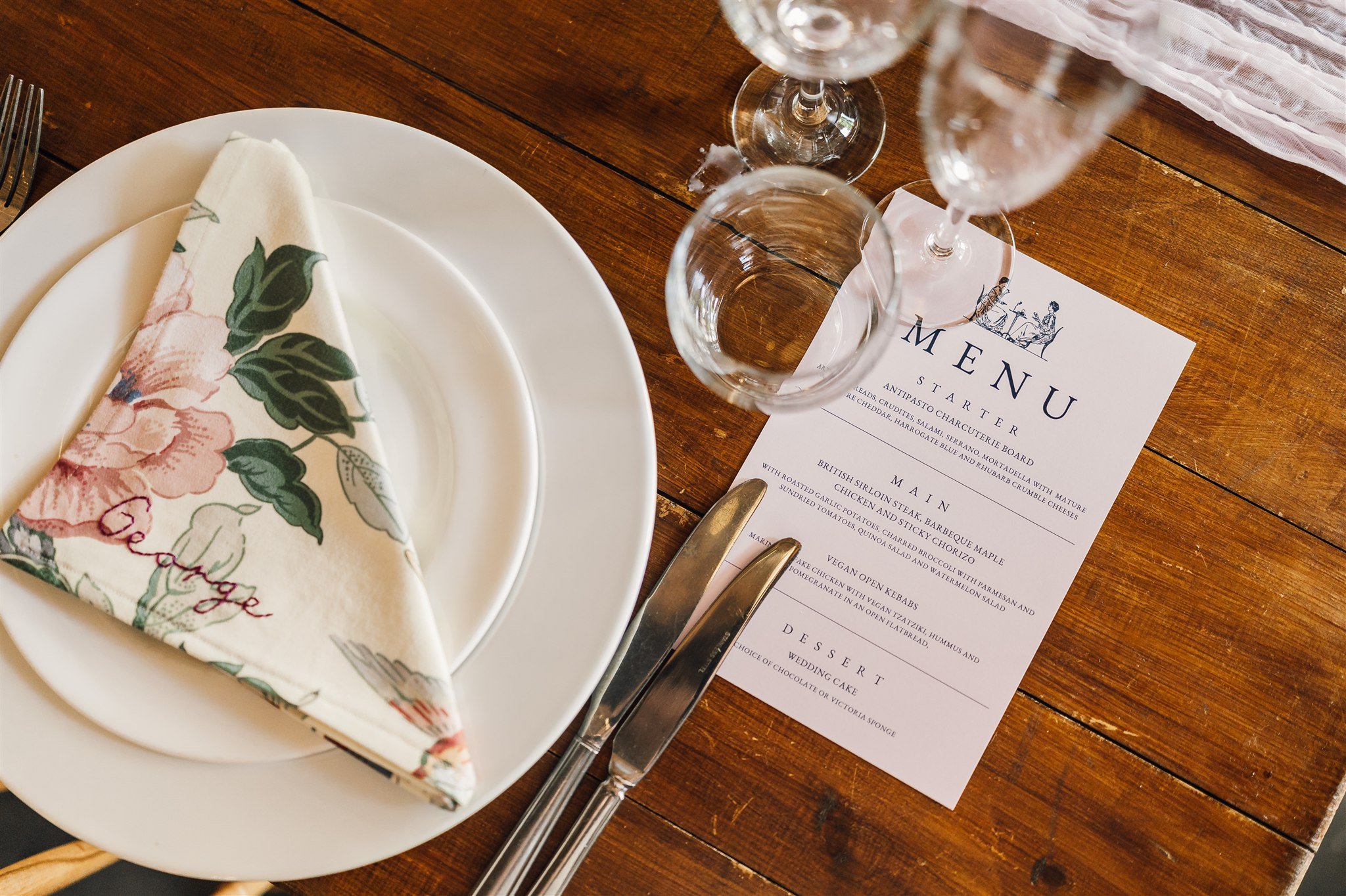 Wedding table styling with floral napkin, menu and glassware at East Riddlesden Hall