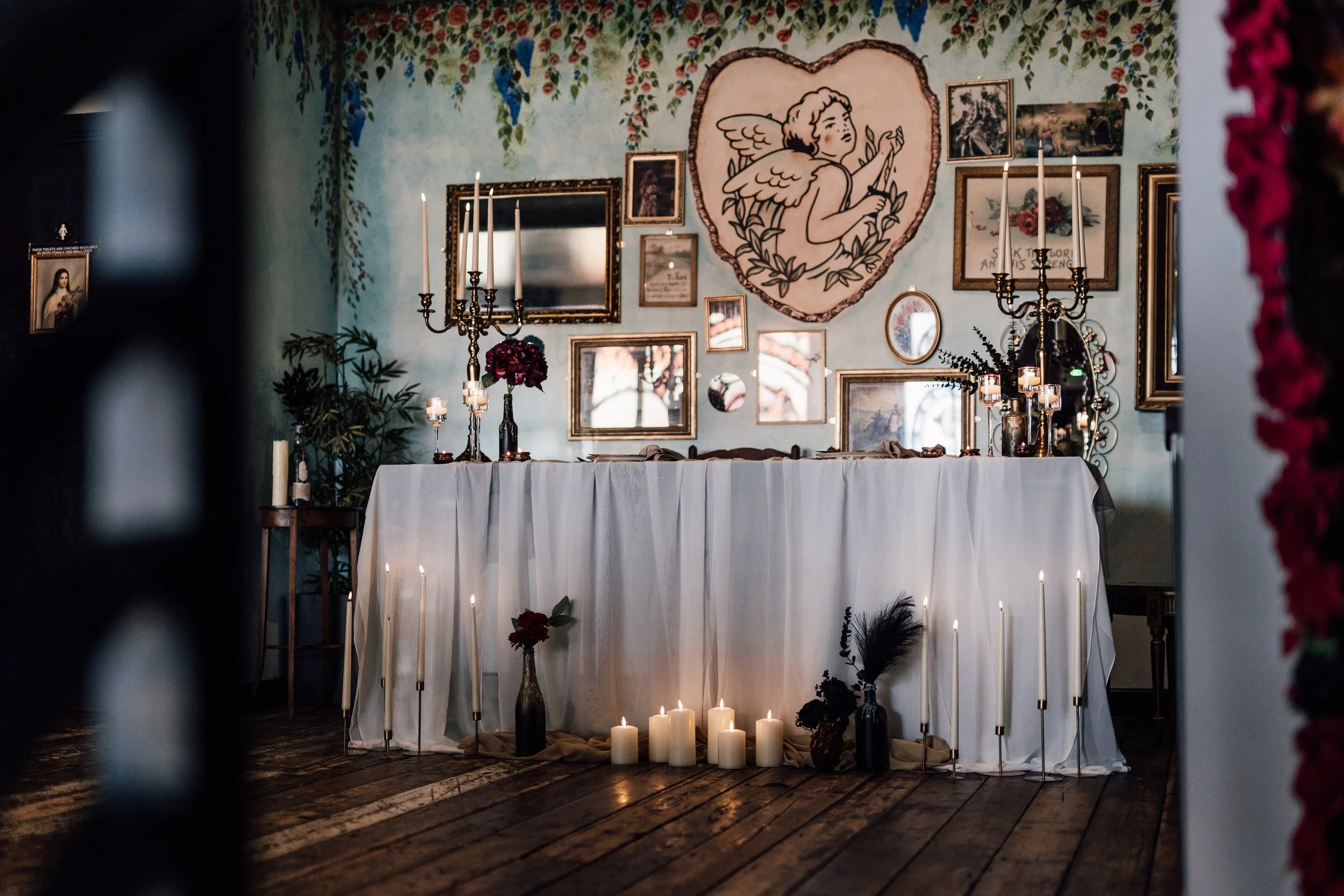 Wedding ceremony setup at Church Temple of Fun Sheffield with candlelit altar, framed artwork wall and floral styling