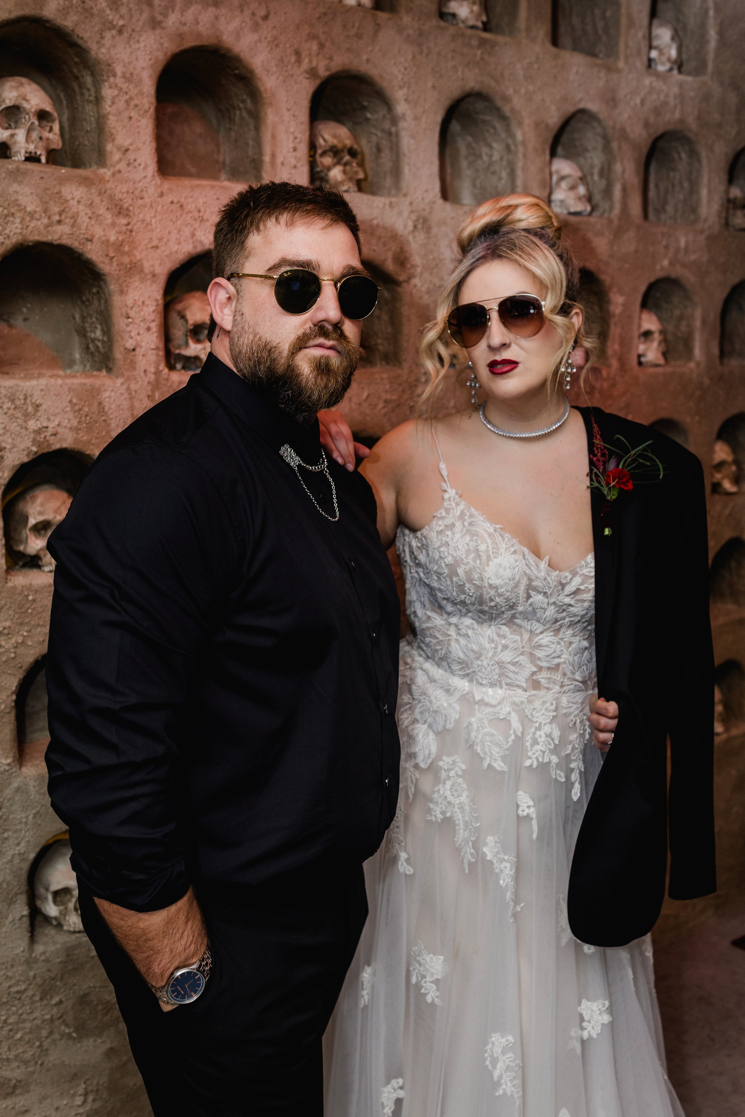 Edgy alternative wedding couple portrait at Church Temple of Fun Sheffield with skull wall backdrop