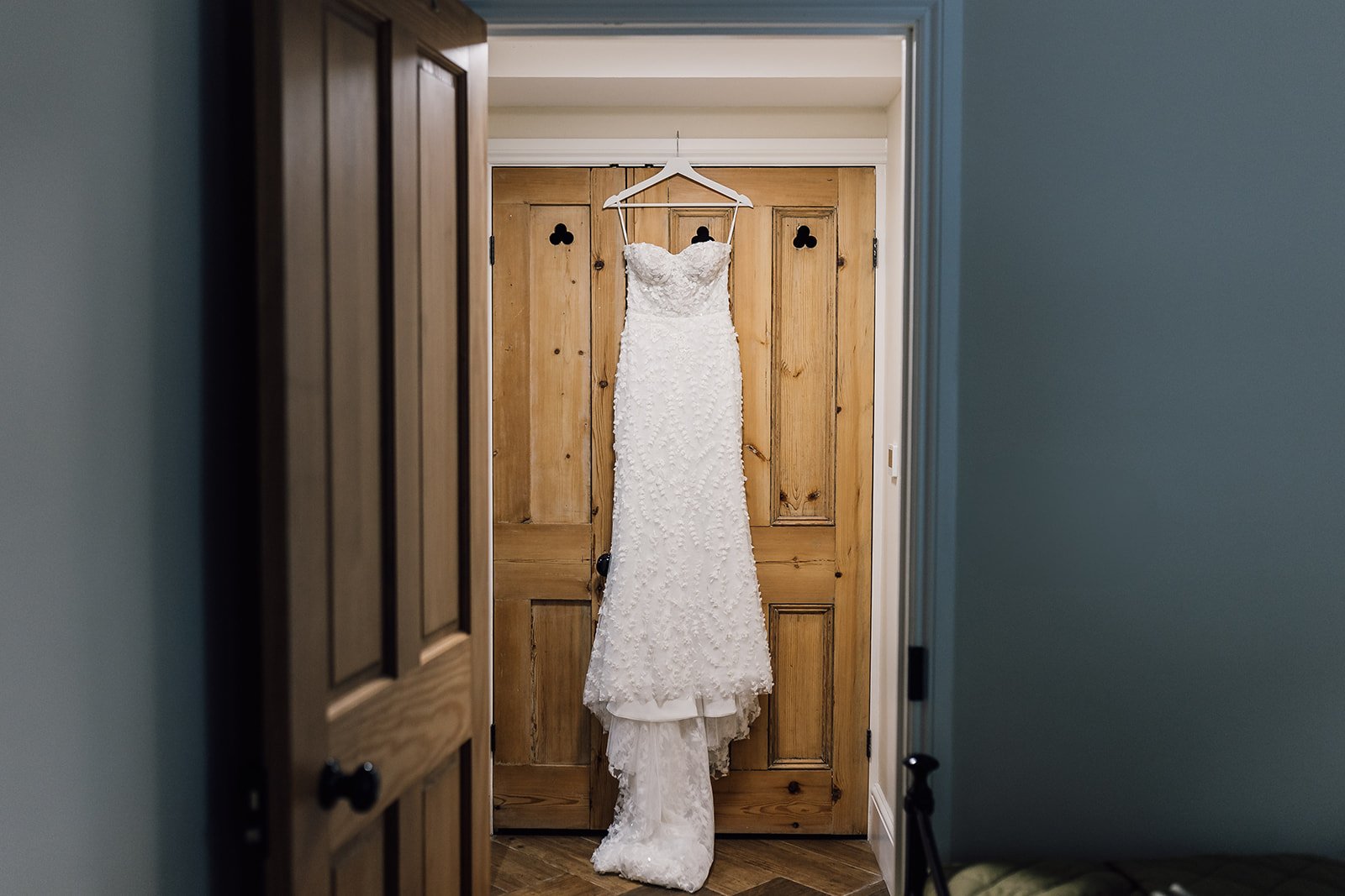 Charlotte’s wedding dress hanging in a doorway