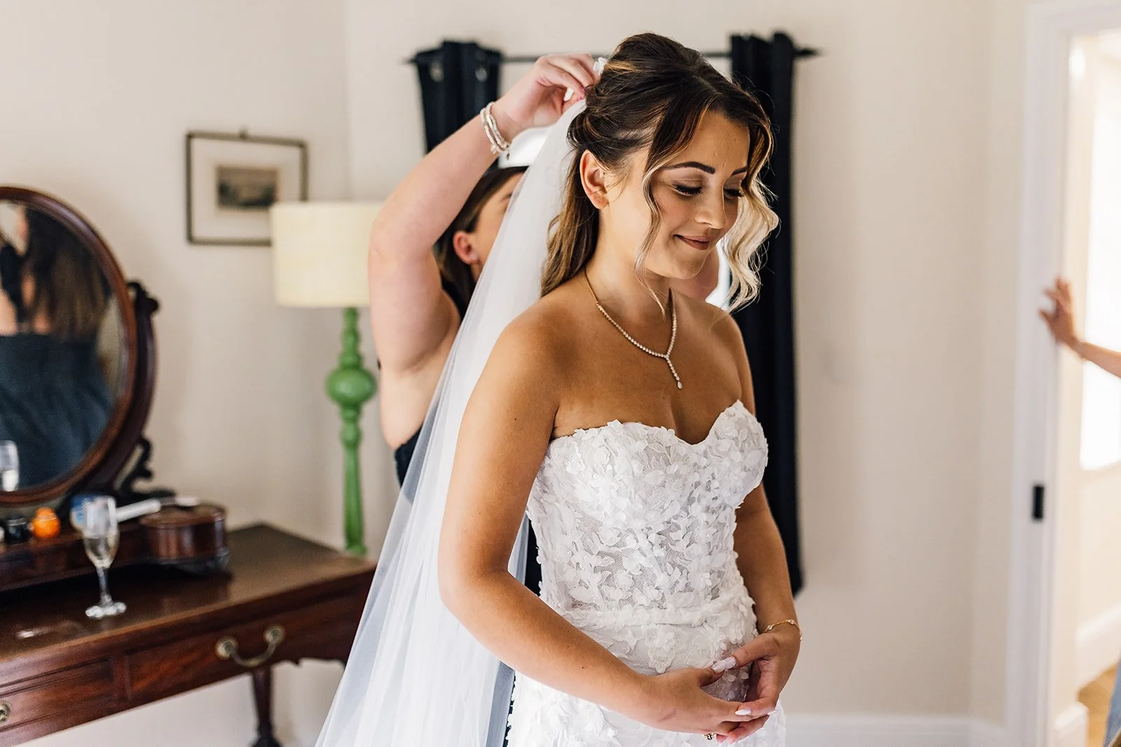 Charlotte smiling as the finishing touches are made to her wedding hair