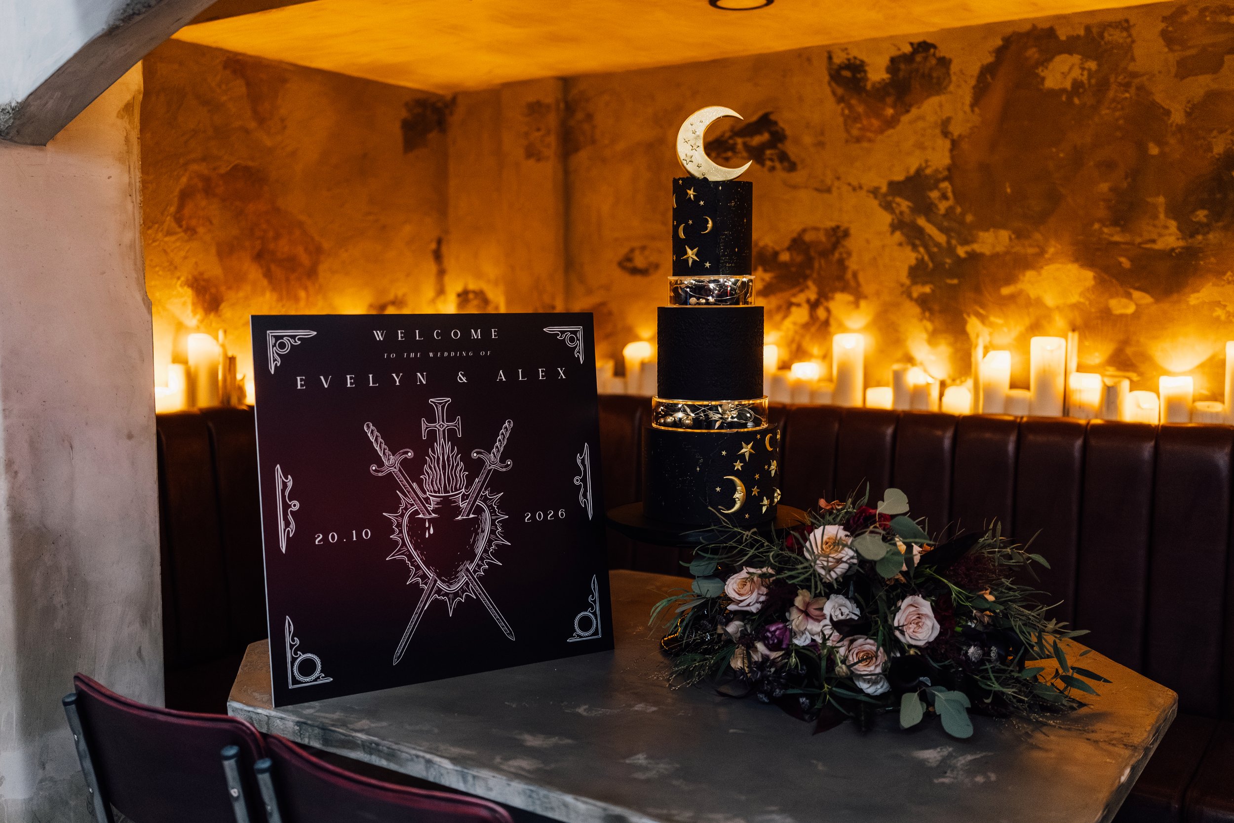 Alternative wedding welcome sign and celestial themed cake at Church Temple of Fun Sheffield with candlelit backdrop