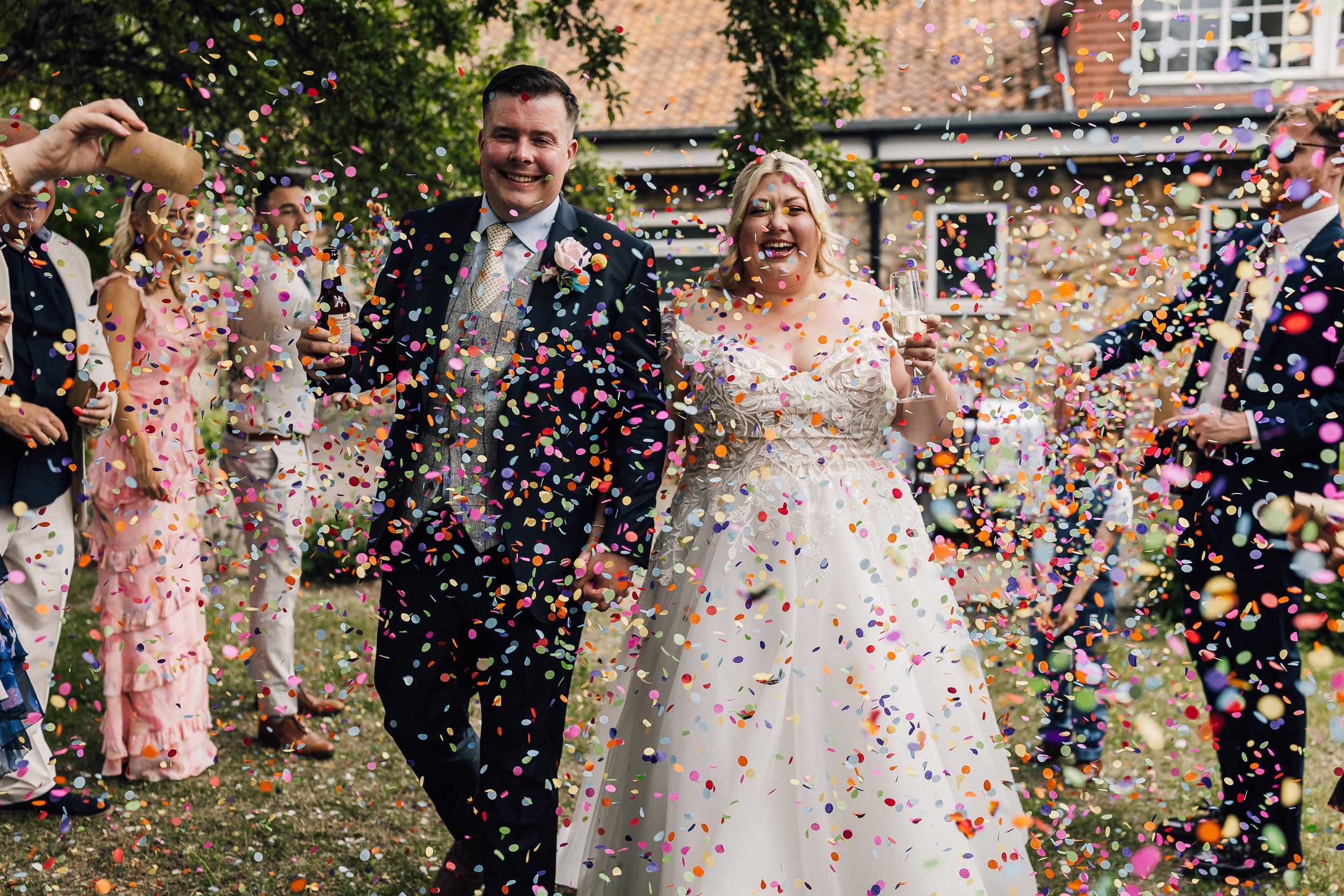 A colourful confetti tunnel moment during a Yorkshire wedding showing how lots of confetti creates incredible wedding photos.