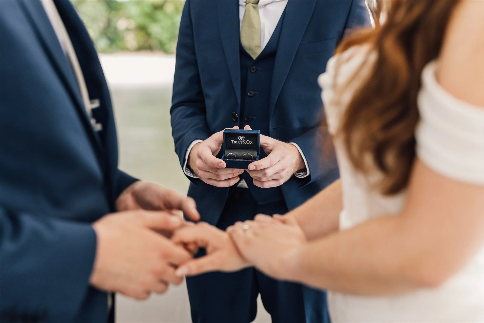 Brother handing bride and groom wedding rings