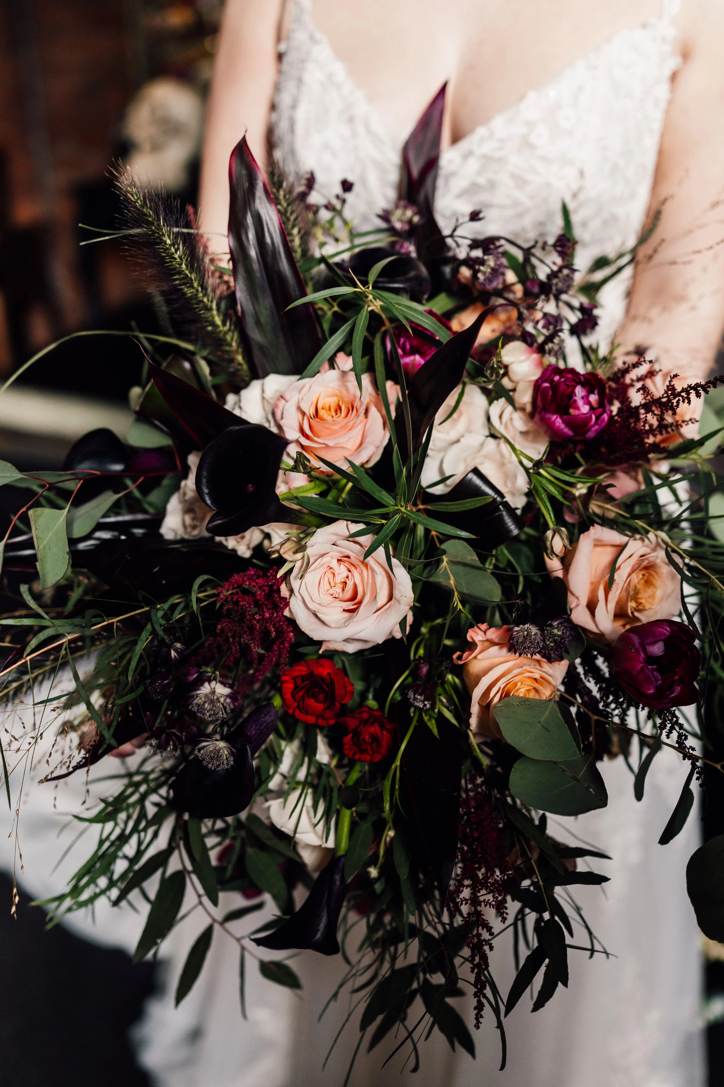 Moody wedding bouquet with dark red and blush flowers alternative wedding style