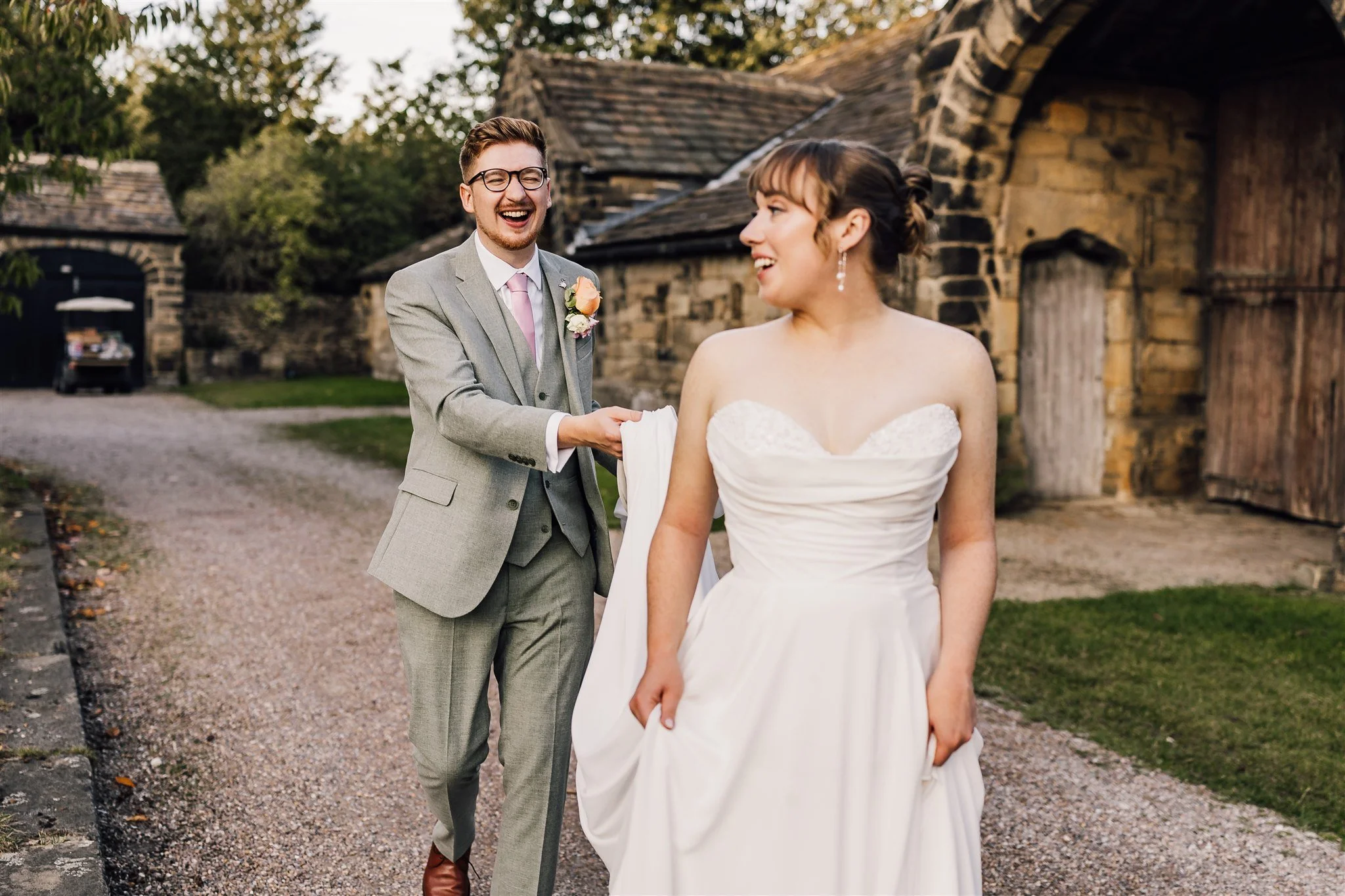 Fun candid moment of groom pulling bride’s dress at East Riddlesden Hall wedding venue