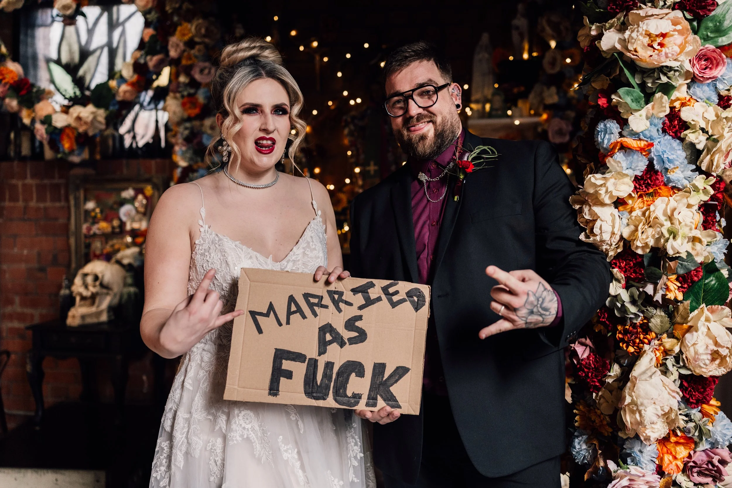 Fun alternative wedding couple with bold “married as fuck” sign at Church Temple of Fun wedding venue Sheffield