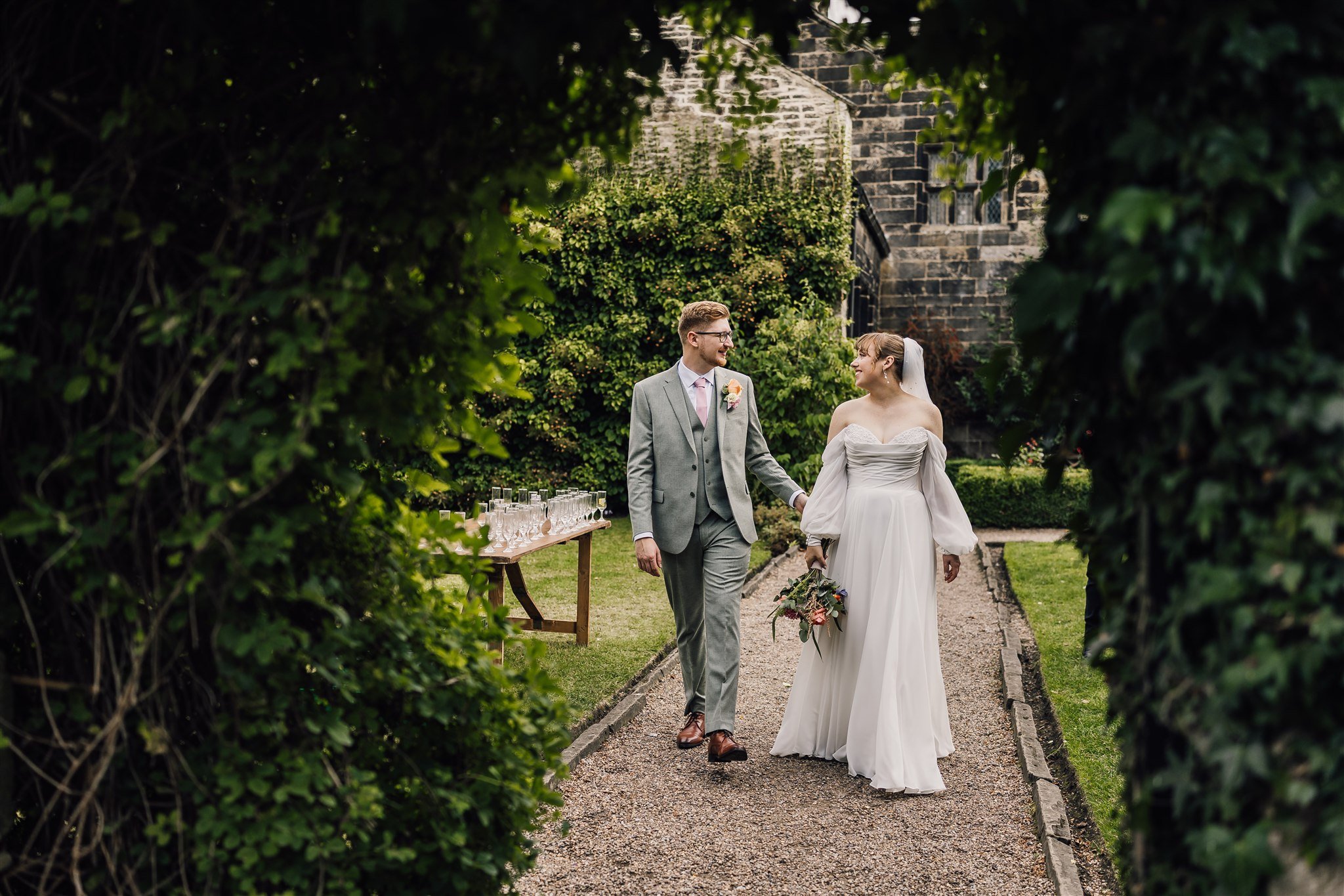 Bride and groom walking through gardens at East Riddlesden Hall wedding venue in West Yorkshire