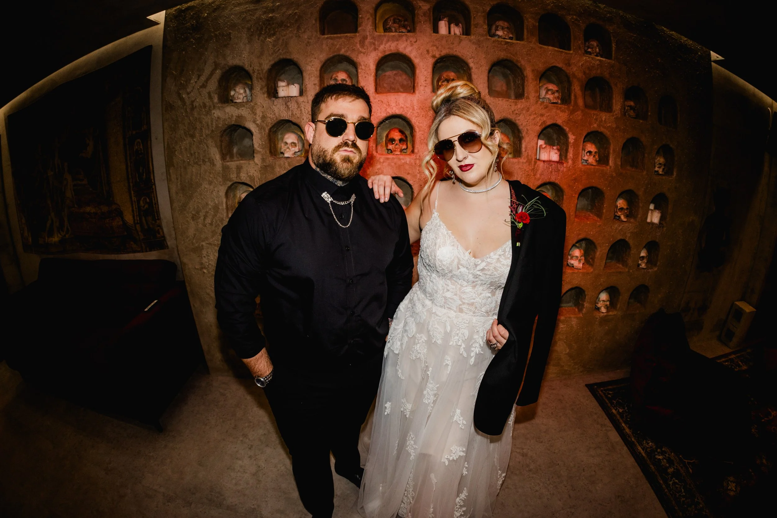 Edgy alternative wedding couple portrait at Church Temple of Fun Sheffield skull wall backdrop