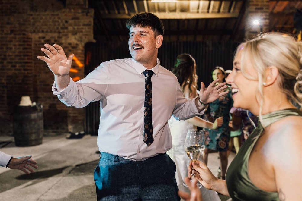Wedding guests singing and dancing together at White Syke Fields