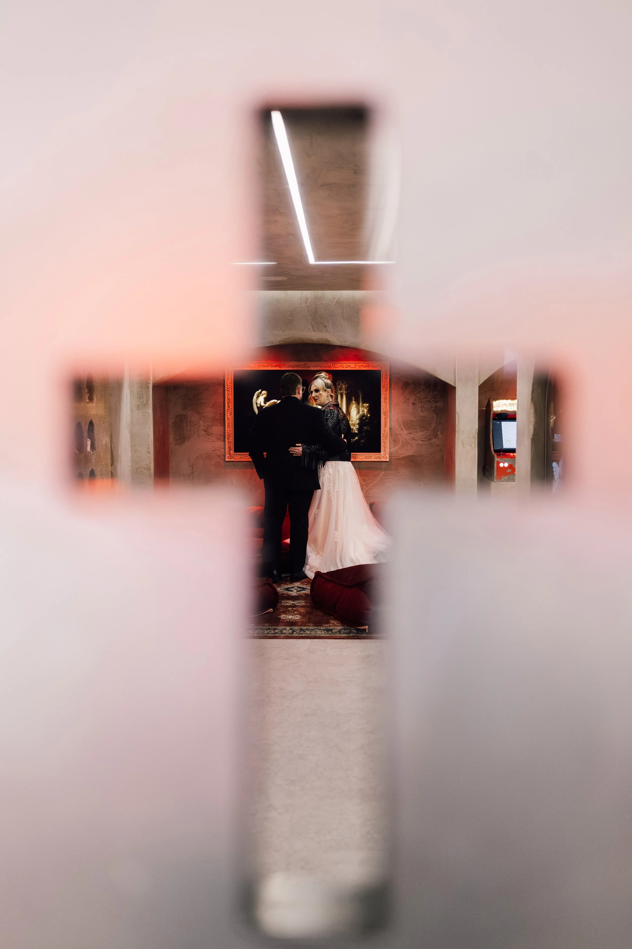 Creative alternative wedding couple framed through cross at Church Temple of Fun Sheffield