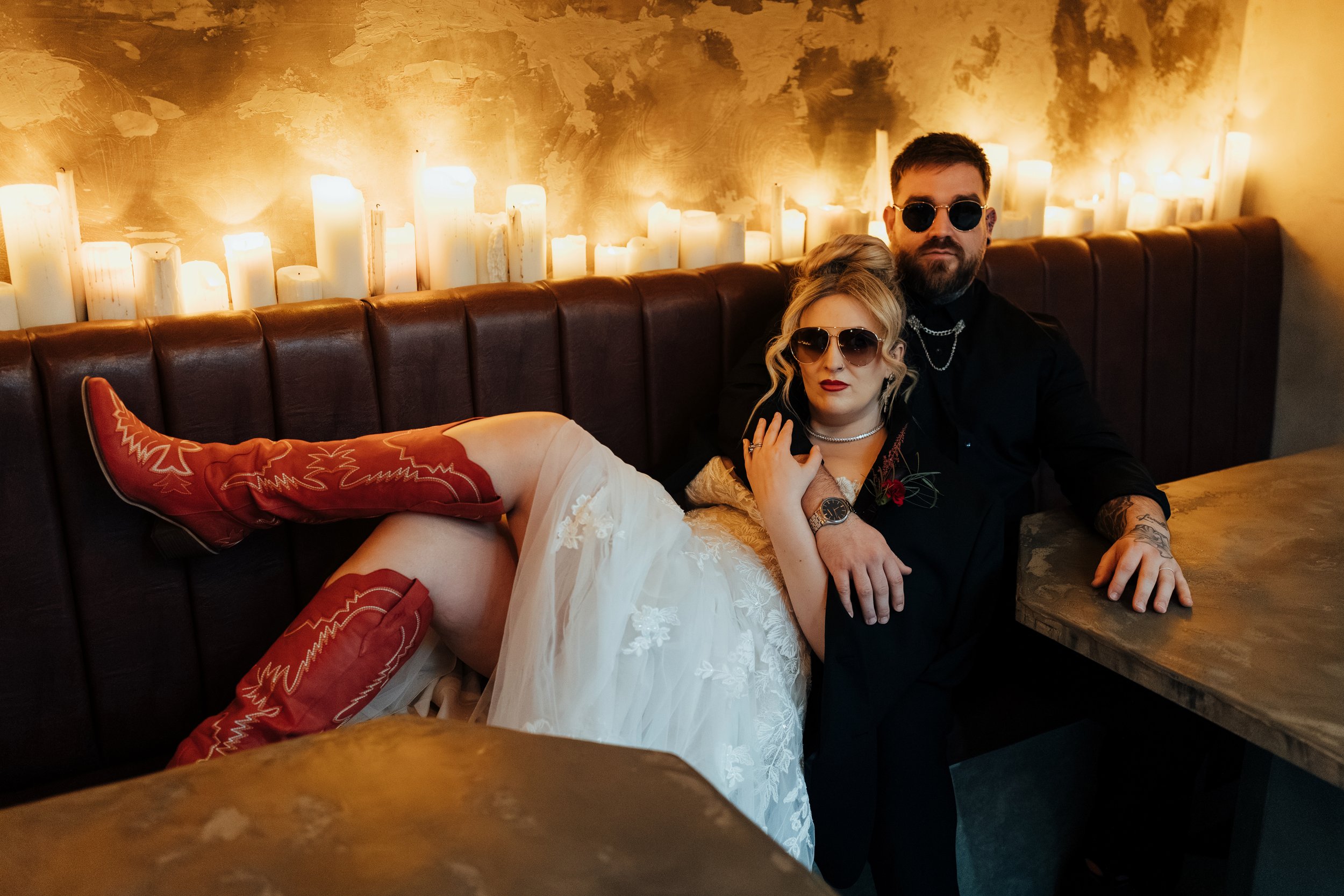 Alternative wedding photography at Church Temple of Fun Sheffield with couple in candlelit booth and moody bar setting