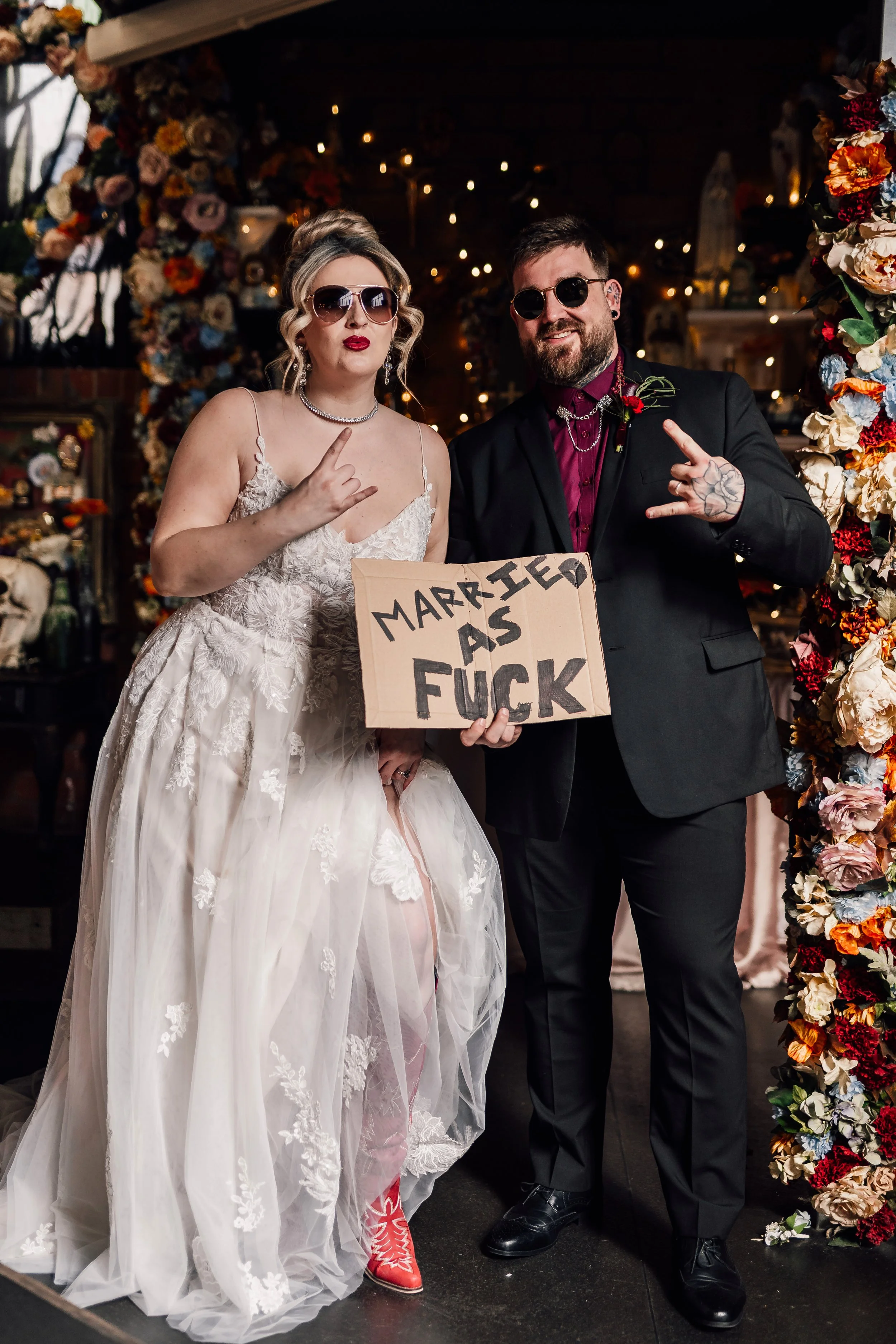 Fun alternative wedding couple with bold “married as fuck” sign at Church Temple of Fun wedding venue Sheffield