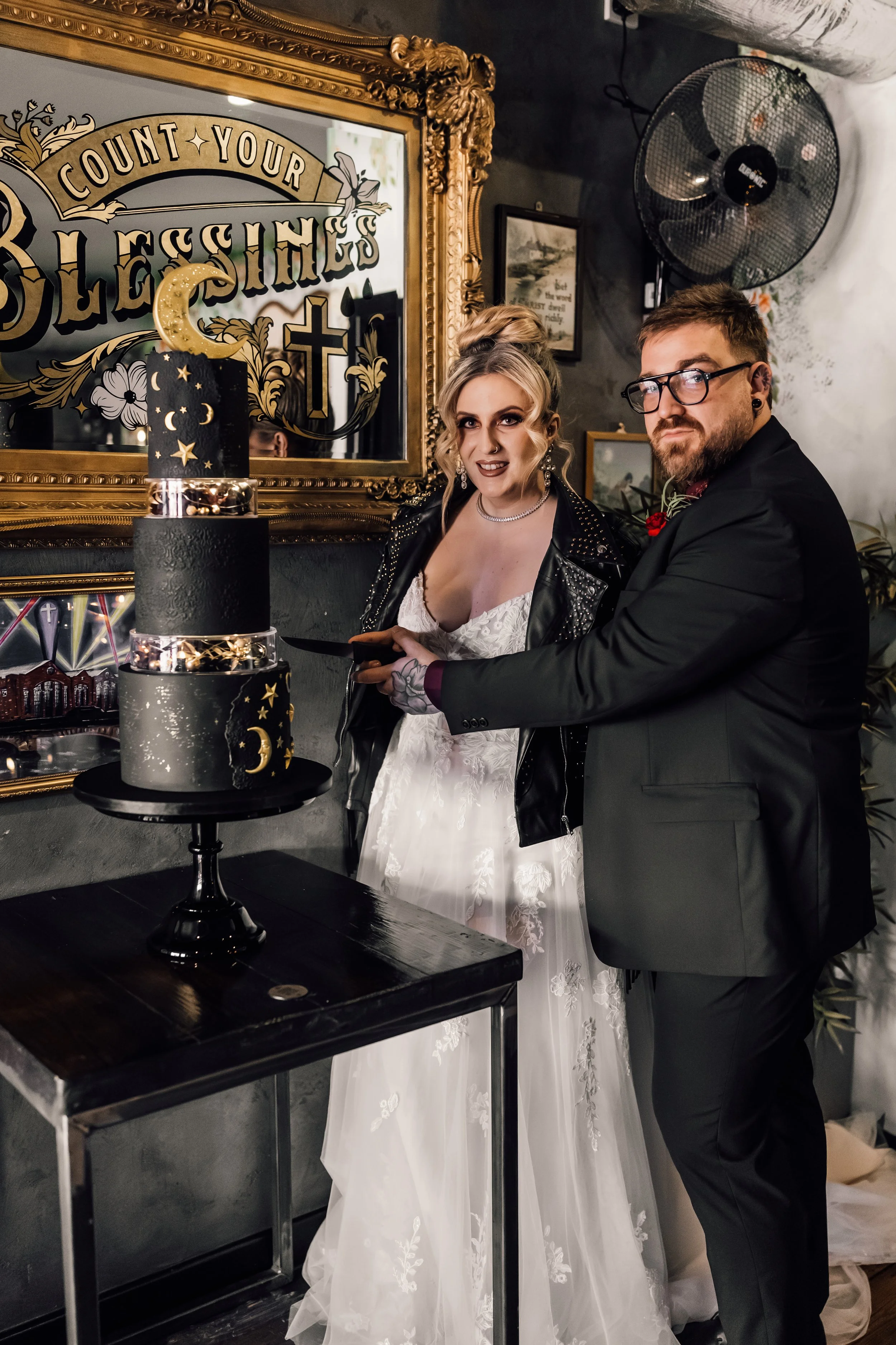 Alternative wedding cake cutting moment with celestial cake and unique styling