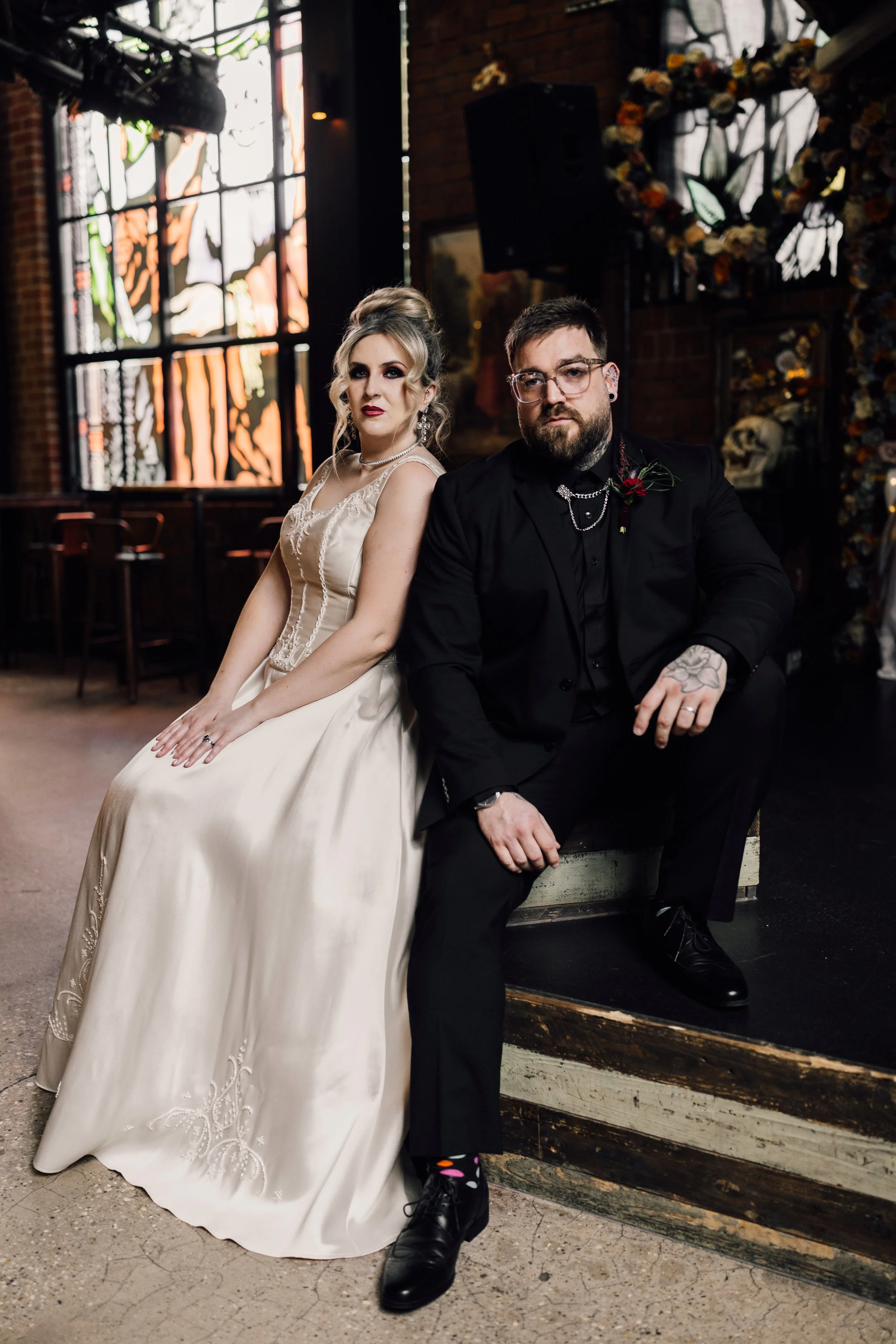 Alternative wedding couple seated on steps at Church Temple of Fun Sheffield wedding venue