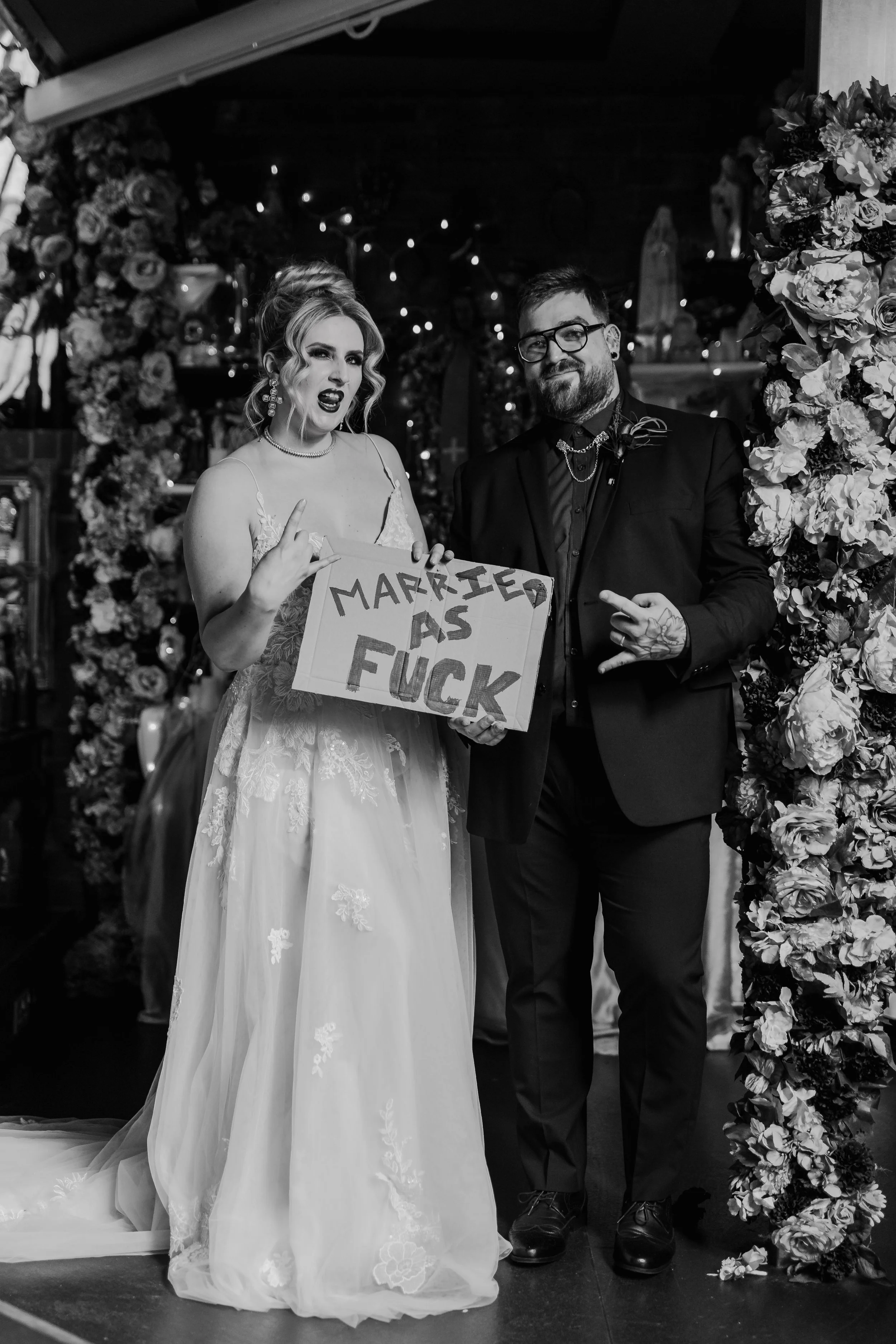Fun alternative wedding couple with bold “married as fuck” sign at Church Temple of Fun wedding venue Sheffield
