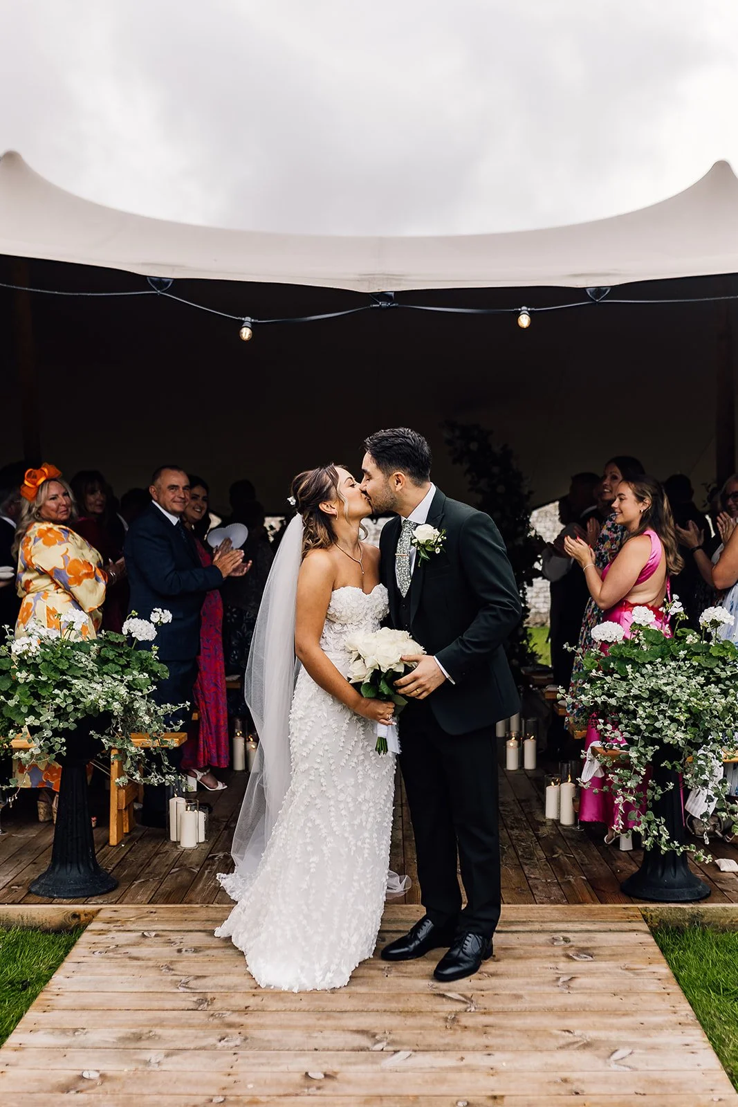 Charlotte and Rory kissing beneath the ceremony canopy