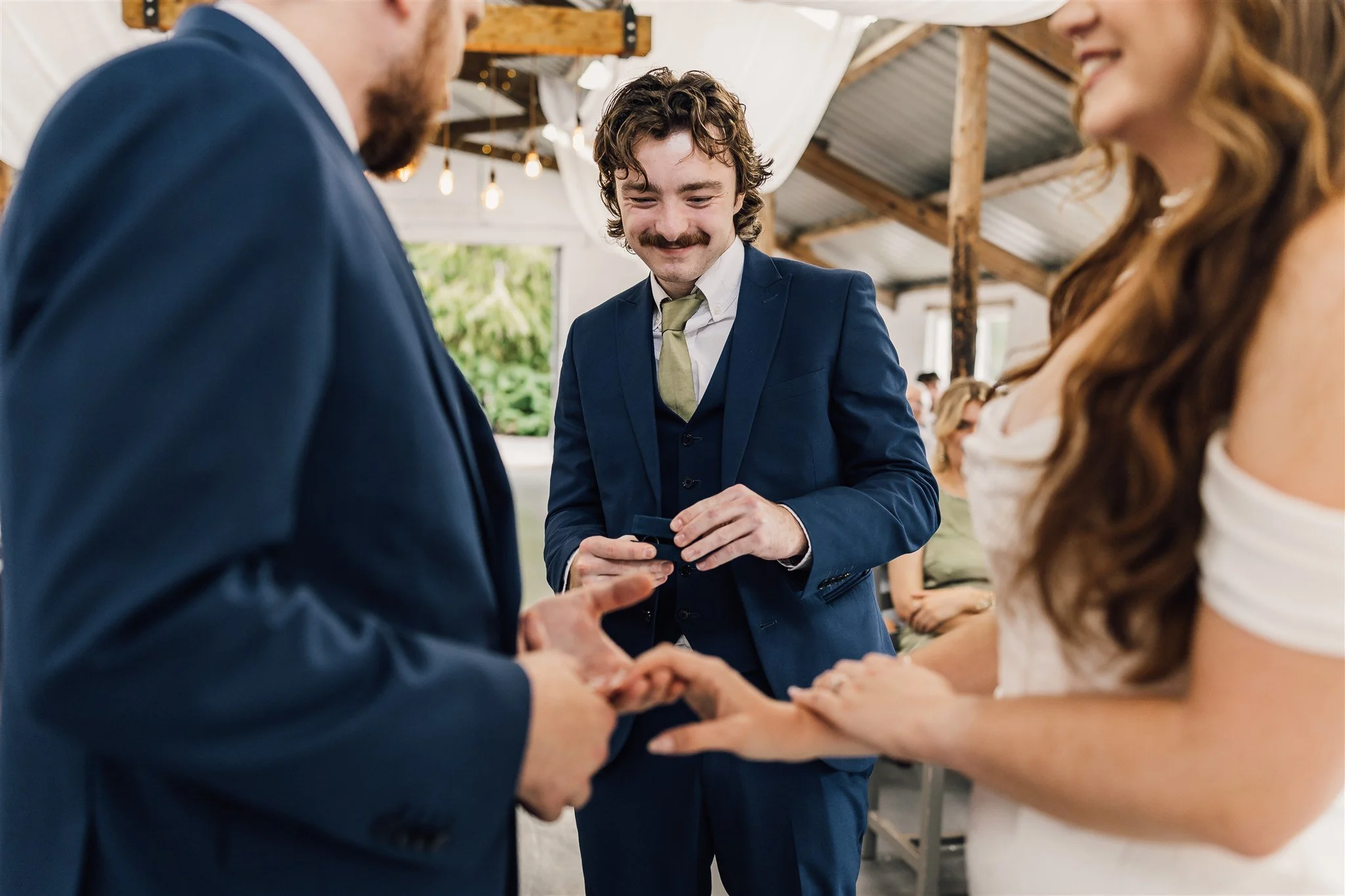 Brother handing bride and groom wedding rings