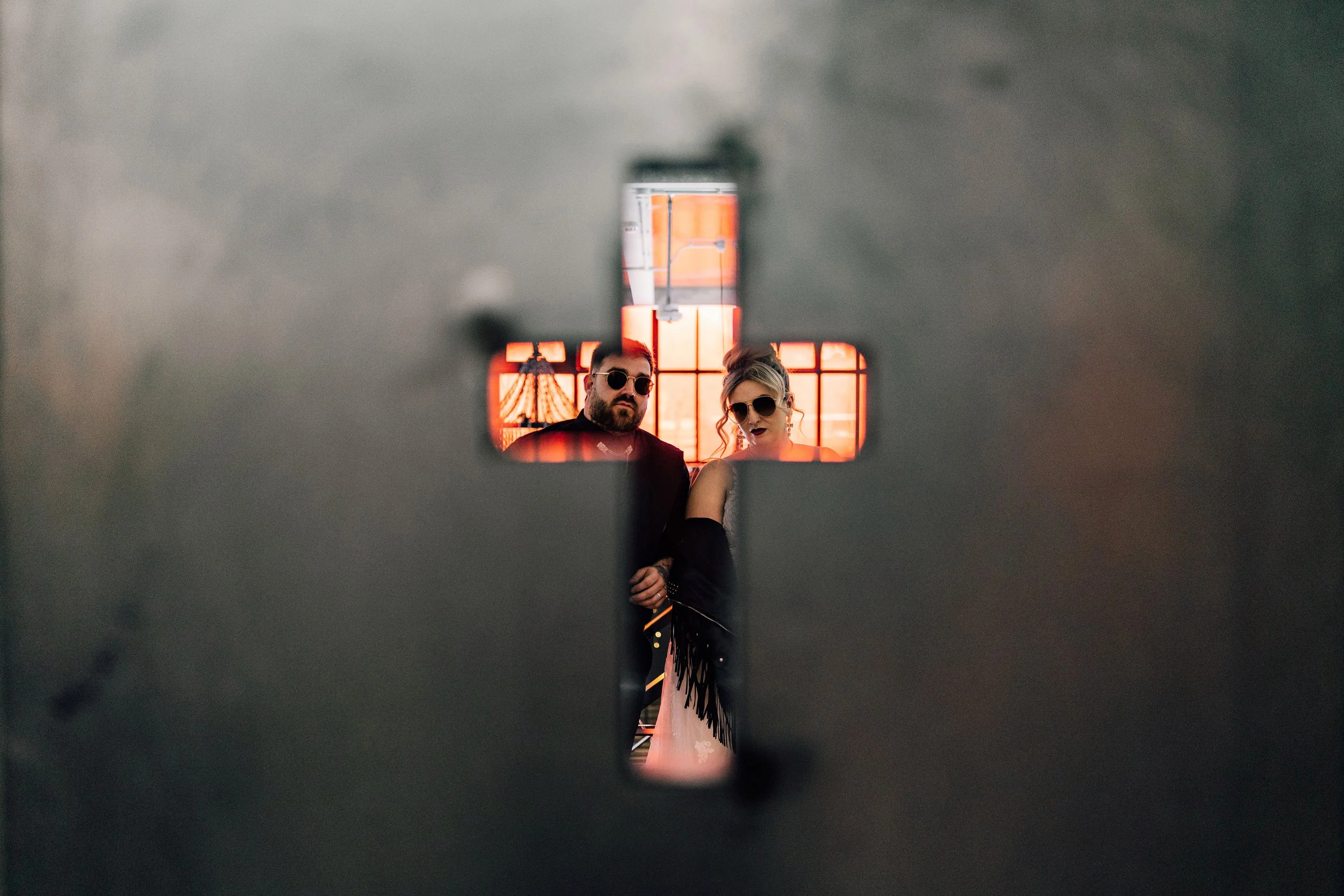 ride and groom framed through cross at Church Temple of Fun wedding Sheffield