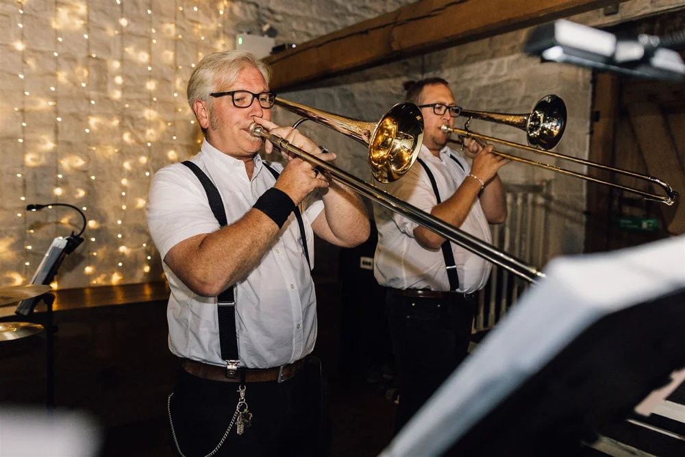 Trombone players performing at Laura and Tom’s evening wedding reception at East Riddlesden Hall