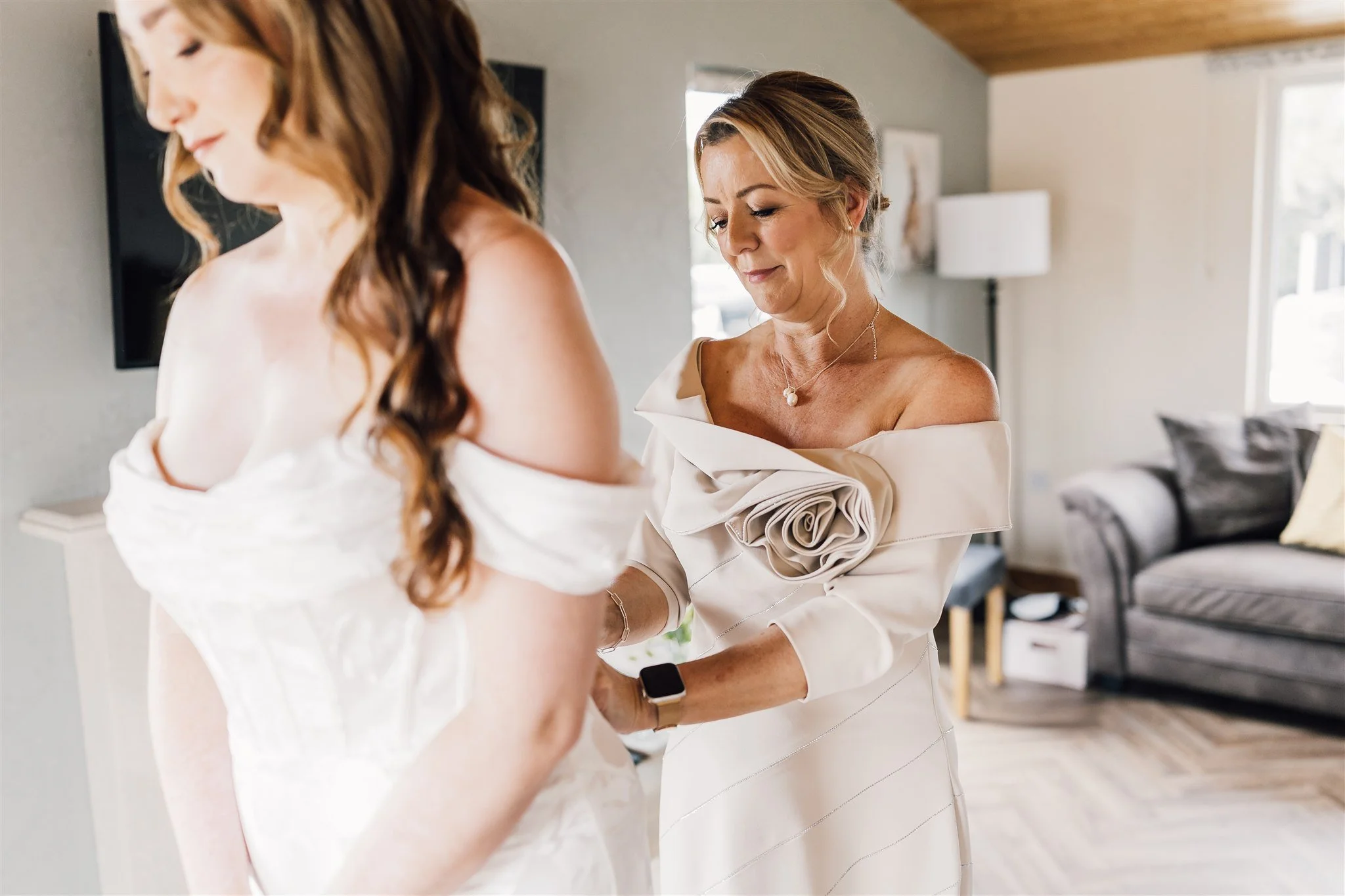 Mum helping bride into her wedding dress